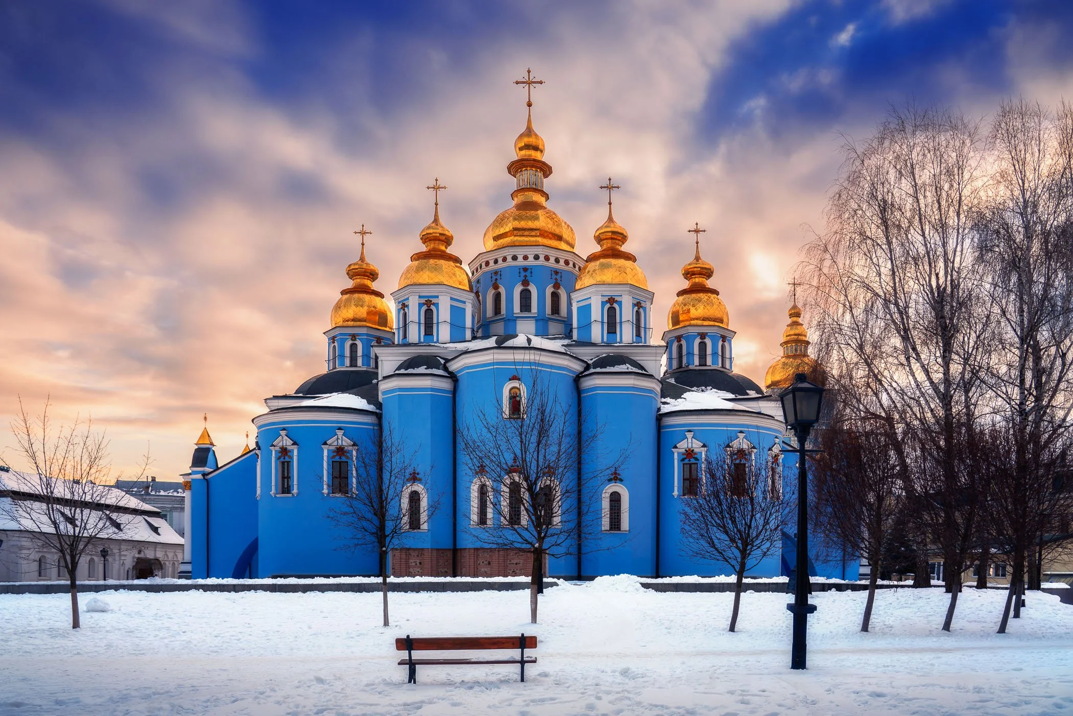Saint Michaels Monastery in Winter A serene winter landscape featuring the sky-blue walls and golden domes of St. Michael's Golden-Domed Monastery.