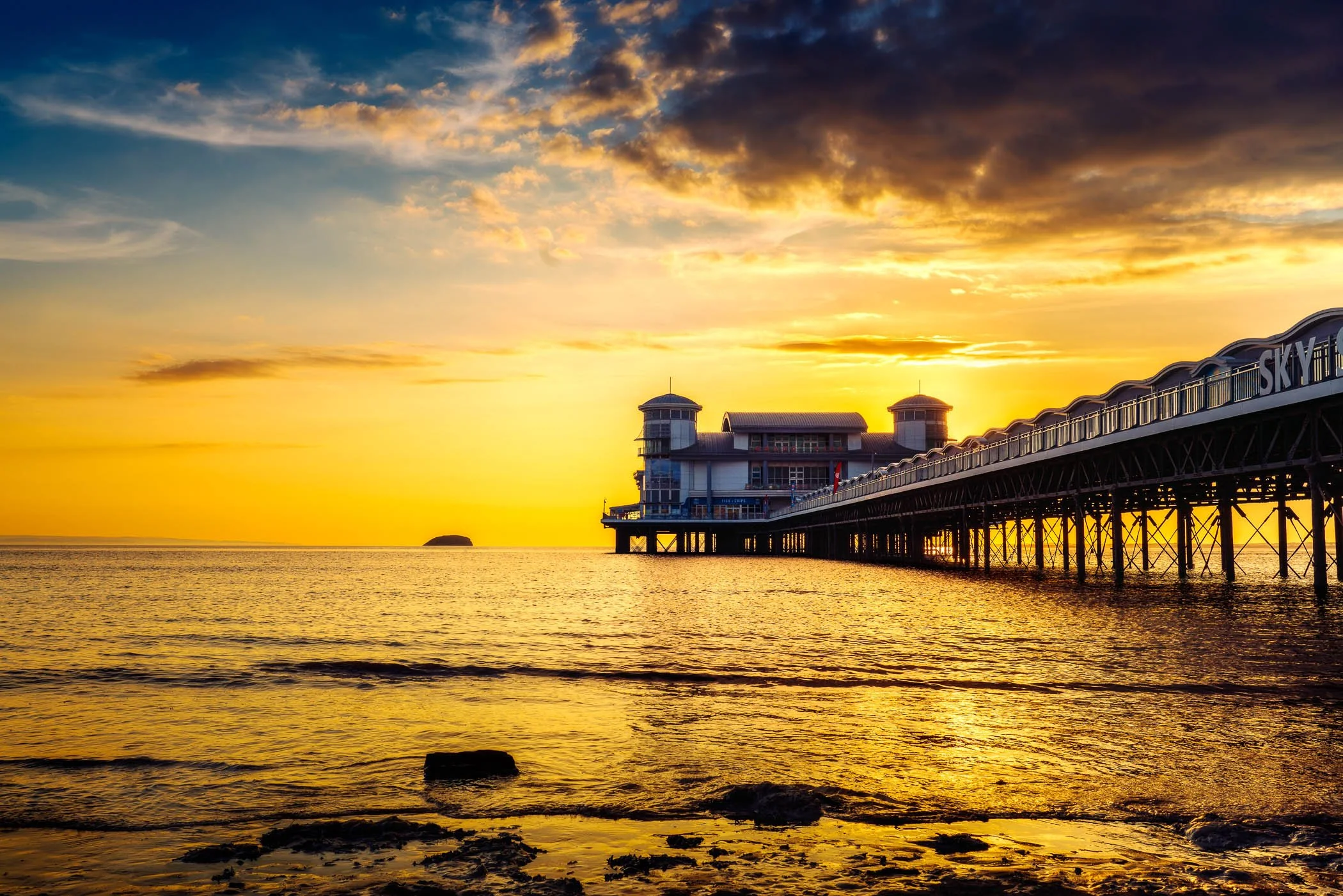 Sunset Sentinel A dramatic silhouette of coastal structure framed by a rich, warm sunset sky.