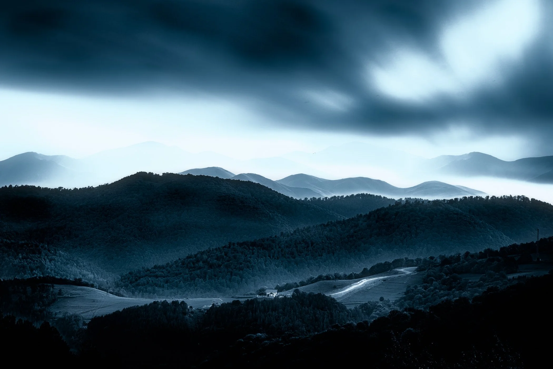 House in the Hills Solitary house surrounded by rolling hills beneath an expansive sky.