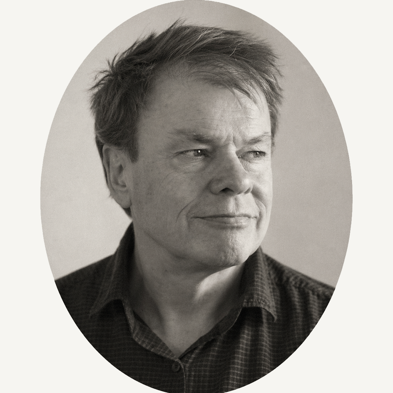 Black and white portrait of the website owner John Wright with short, slightly messy hair and a subtle smile, wearing a collared shirt.