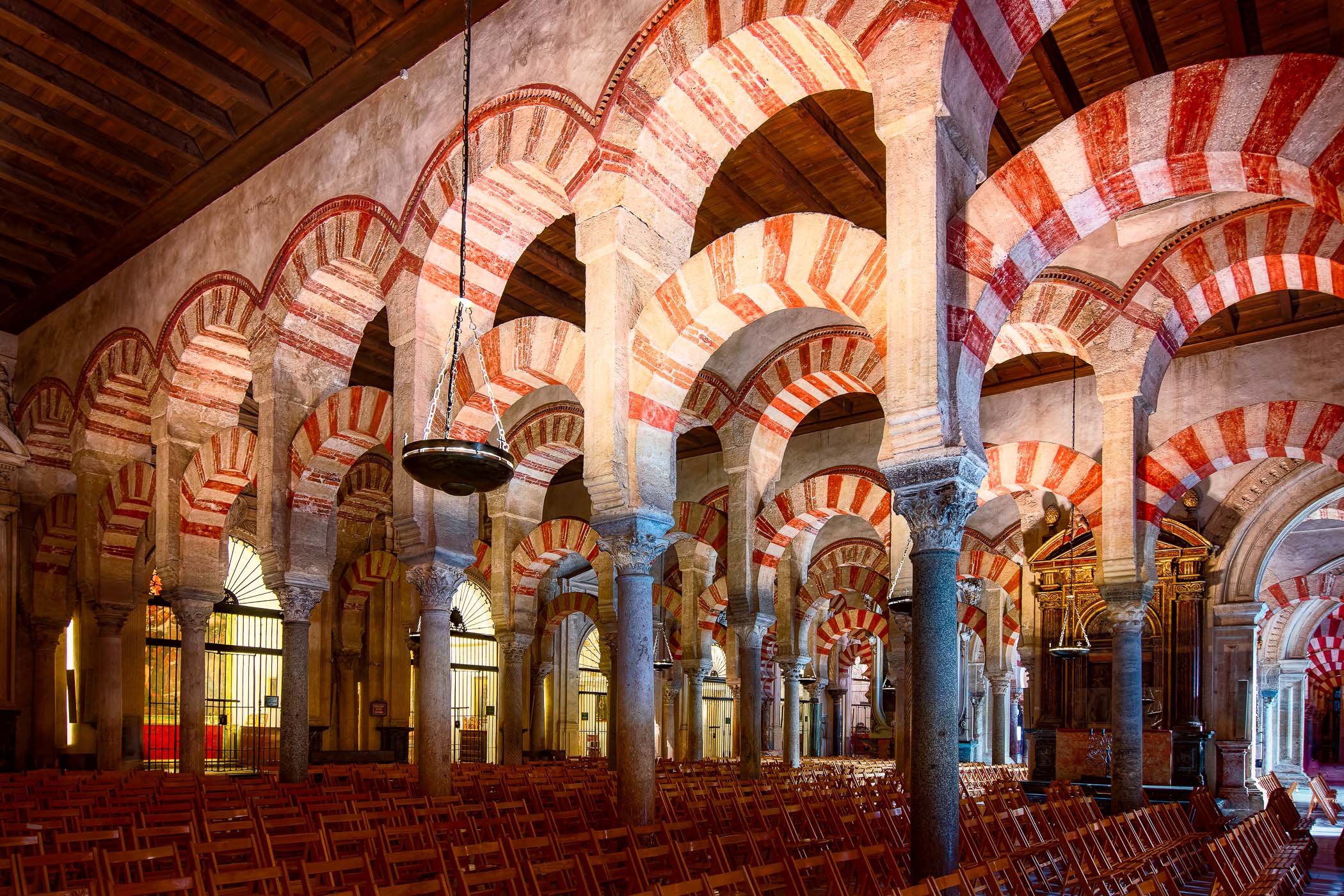 The Iconic Arches of Cordoba Rhythmic red-and-white double arches forming a forest of stone inside the Mezquita.