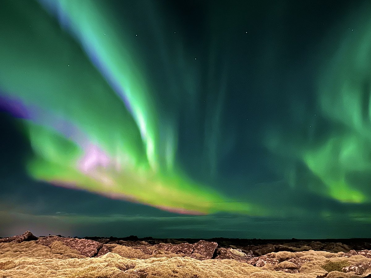 Aurora borealis illuminating the night sky above Iceland’s rugged terrain