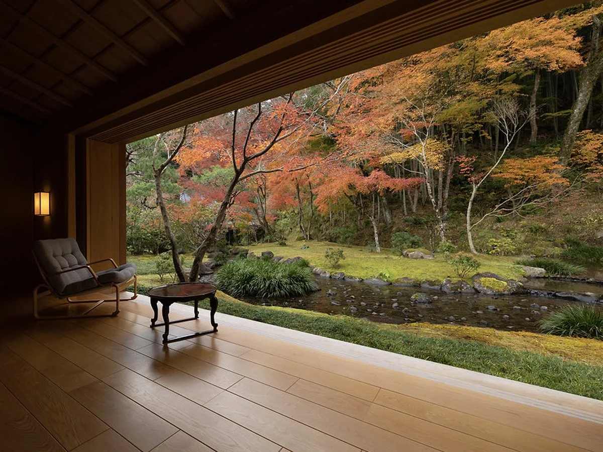 Traditional ryokan guest room at Asaba Ryokan overlooking a Japanese garden with autumn foliage in Shuzenji, Japan