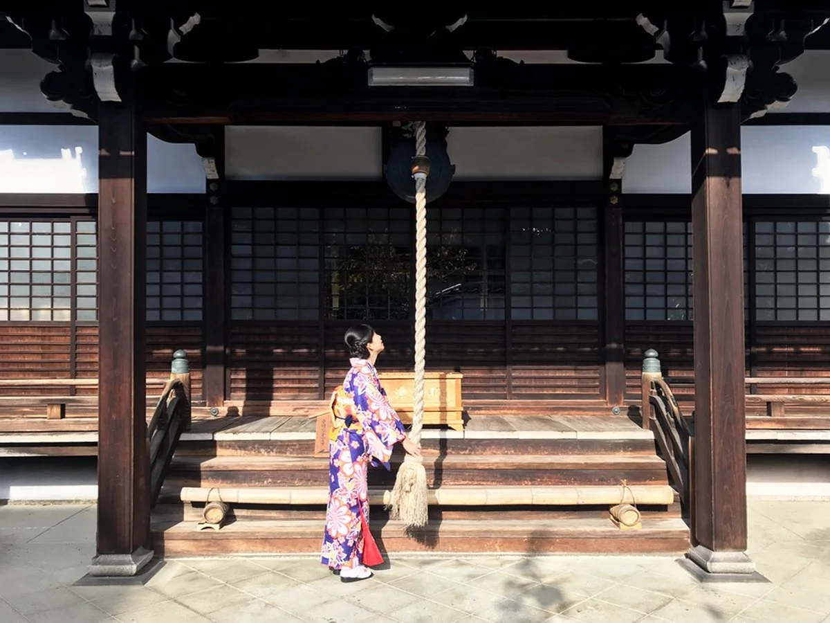 raveler wearing a kimono walking through a historic street in Kyoto, Japan
