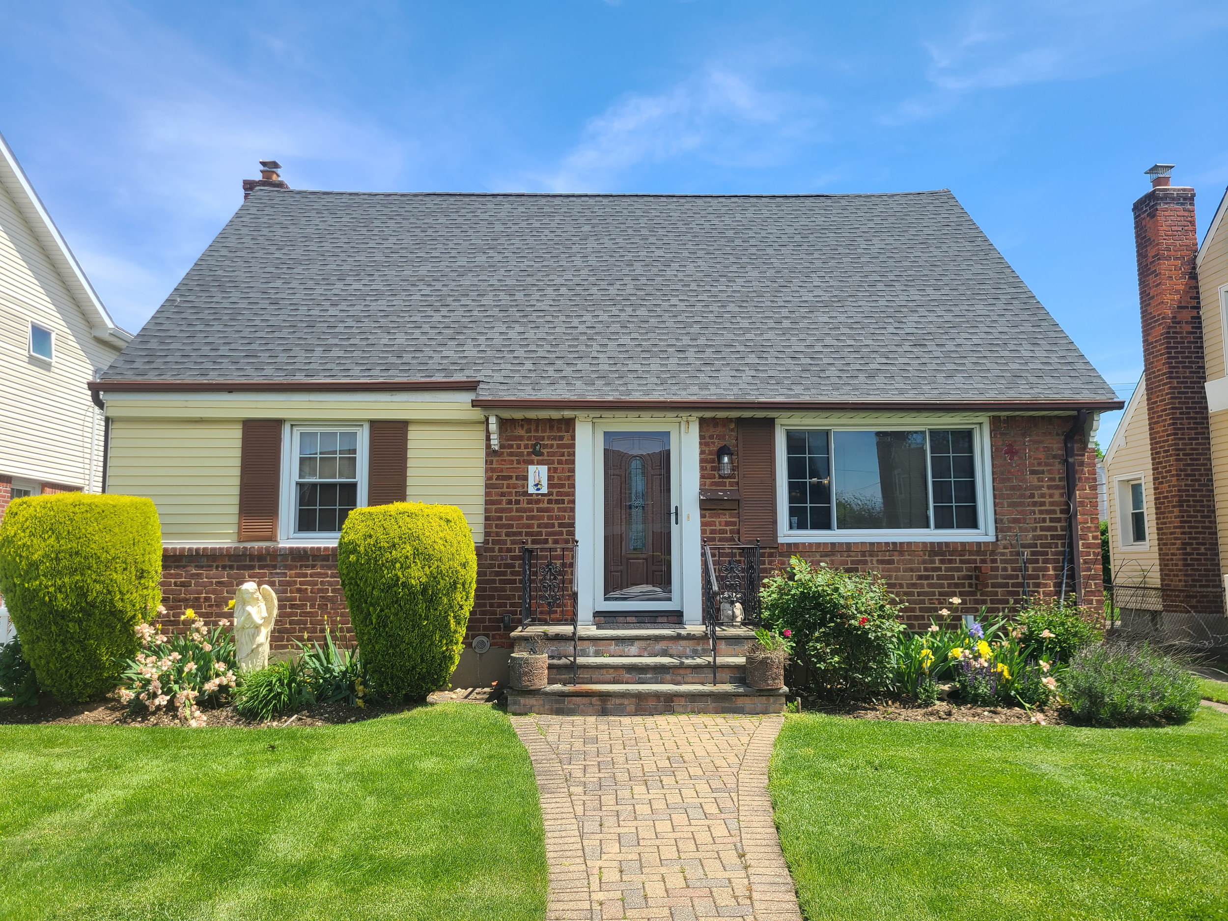 Original Cape-style home exterior prior to renovation in Nassau County, NY by Americana Architects.