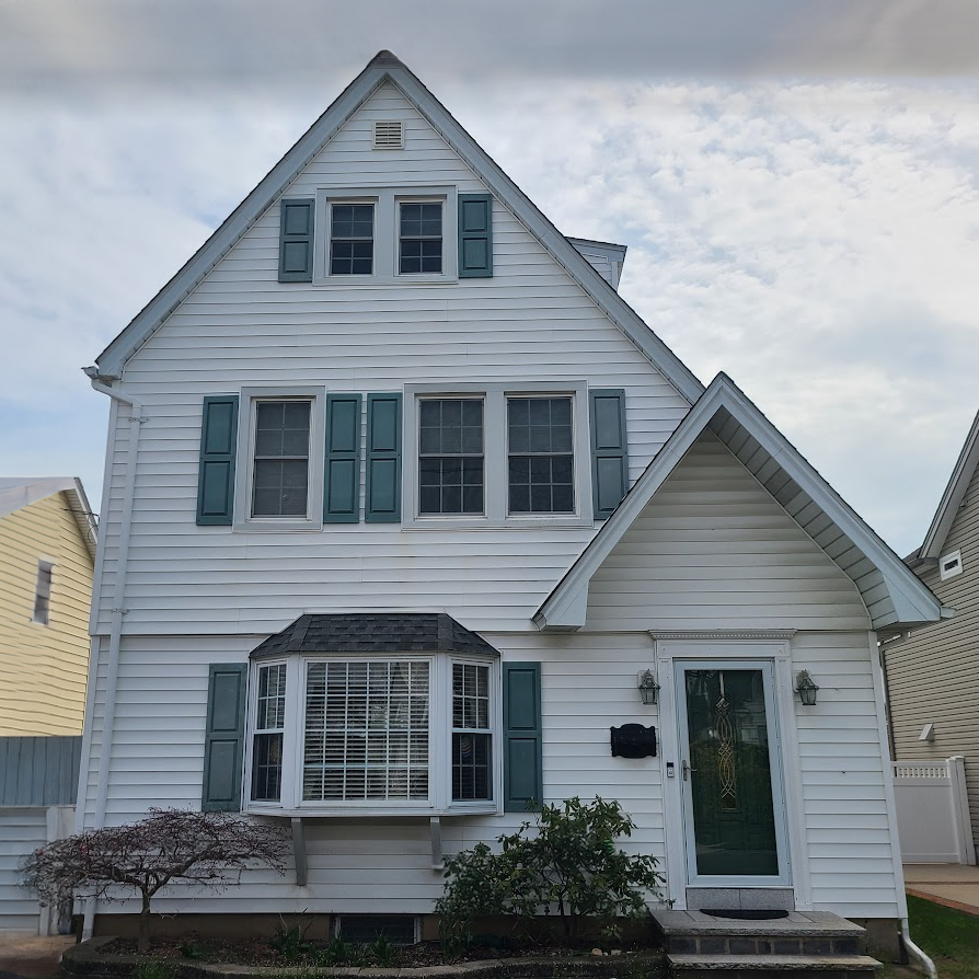 Original front exterior of a Cape-style home in Williston Park, NY before second floor addition and renovation by Americana Architects.