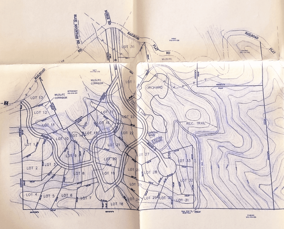 A detailed topographic and land development map showing lots, roads, trails, and natural features like an orchard and wildlife corridor.