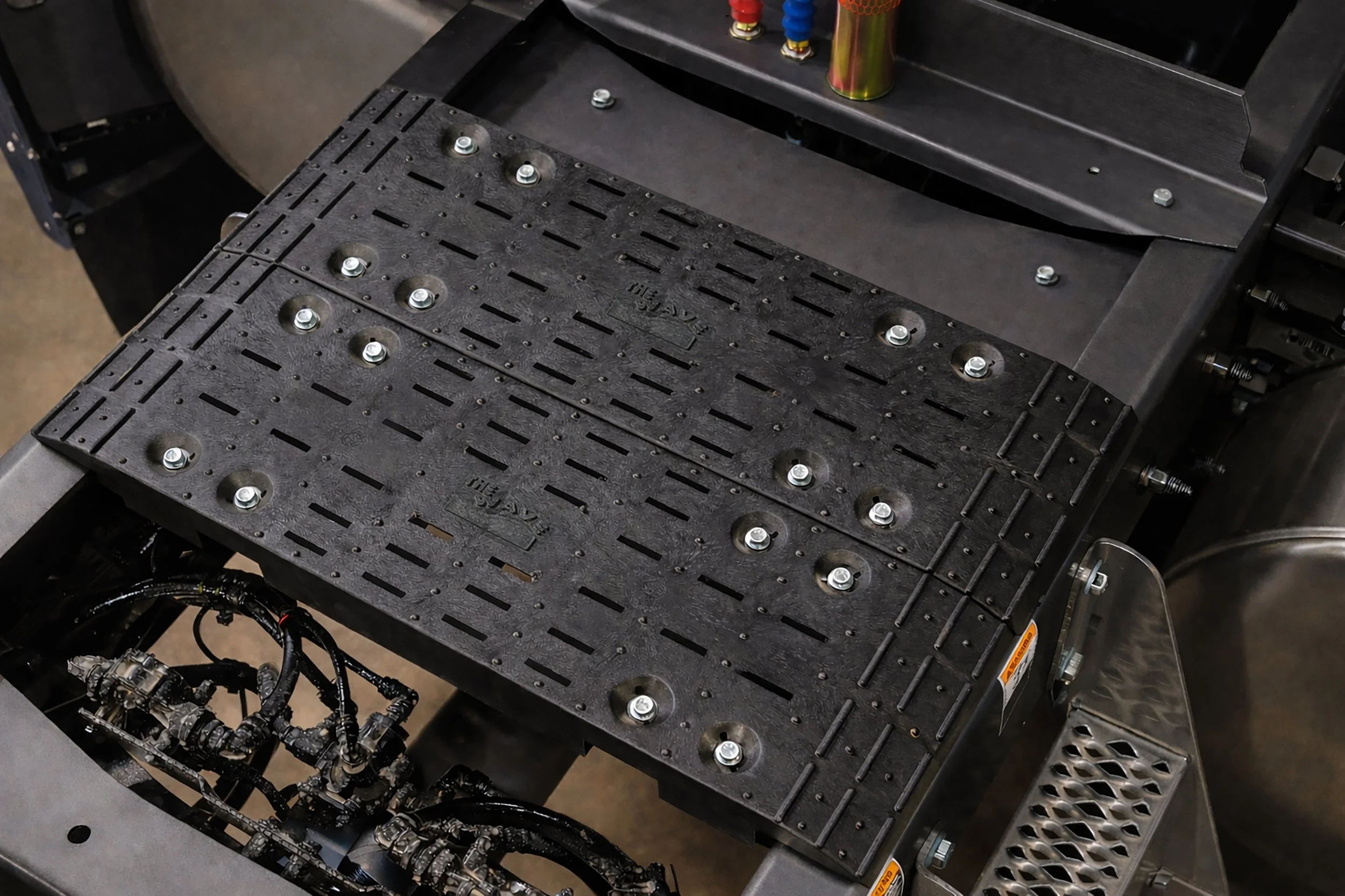 Close-up of an installed 20" Wave Deck catwalk mounted on a mack truck. 