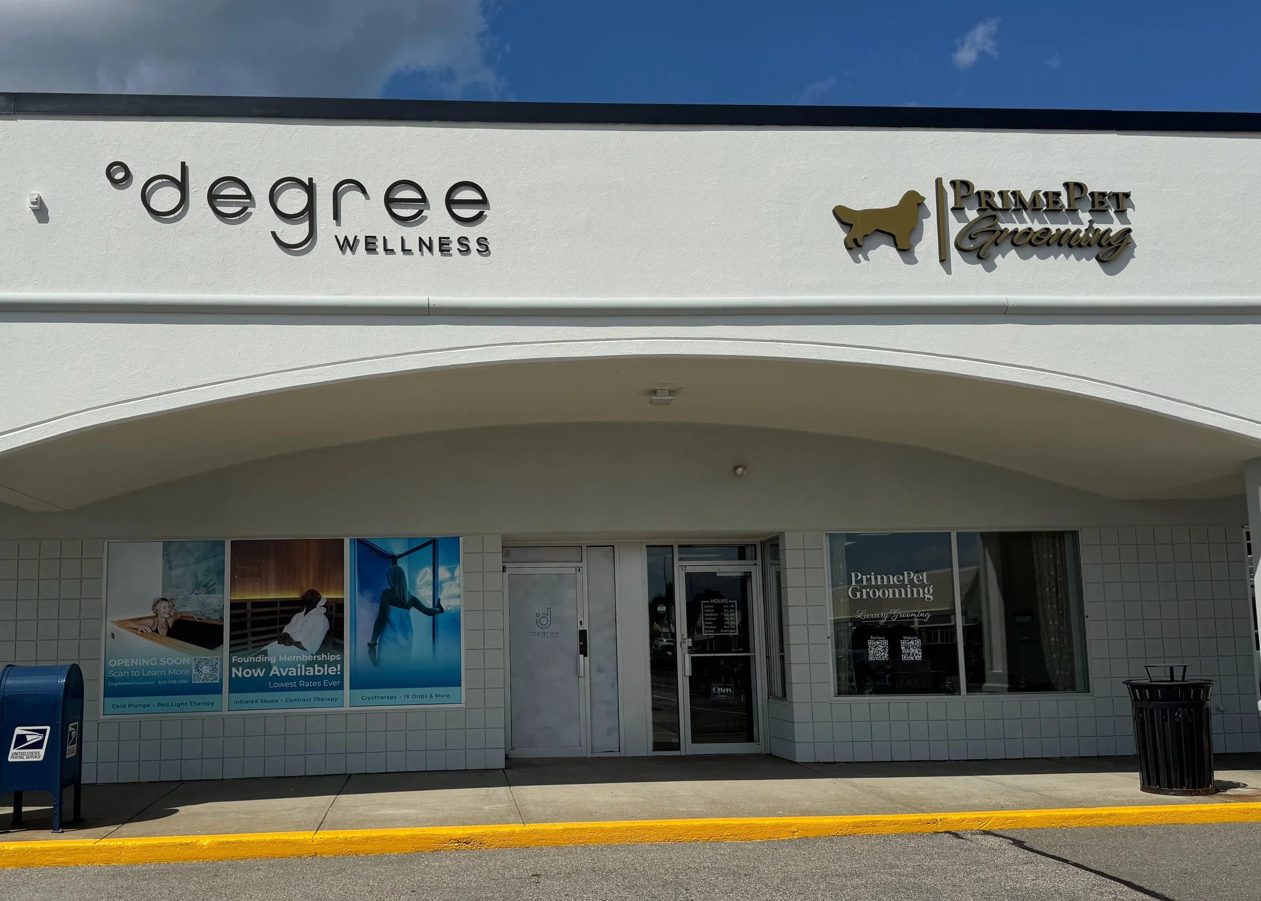 Front view of a wellness and grooming store with signs that read 'degree WELLNESS' and 'PrimePet Grooming', including details about the services offered and an 'Open' sign on the door.