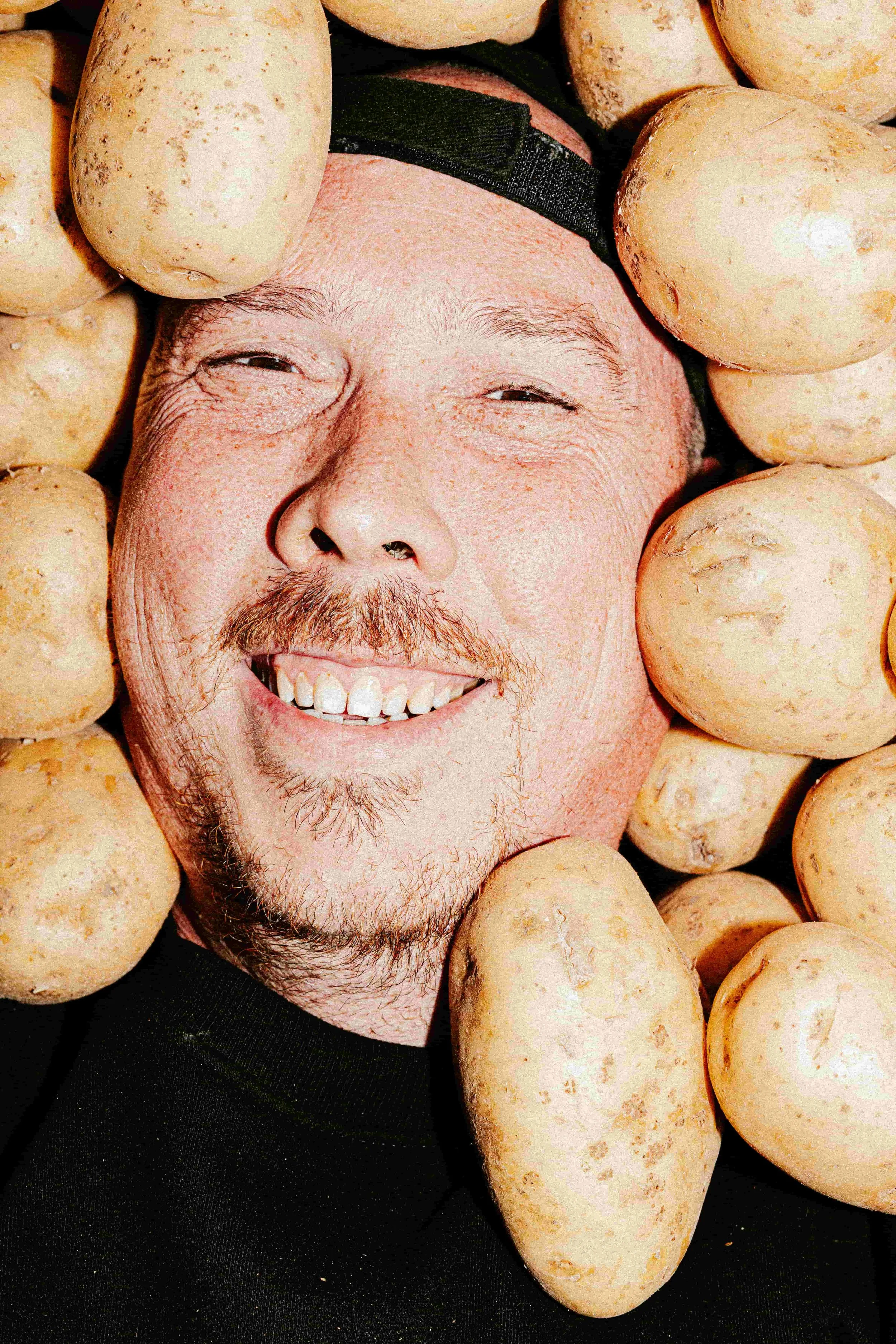 le fondateur de la friterie Barkette couché sur des patates