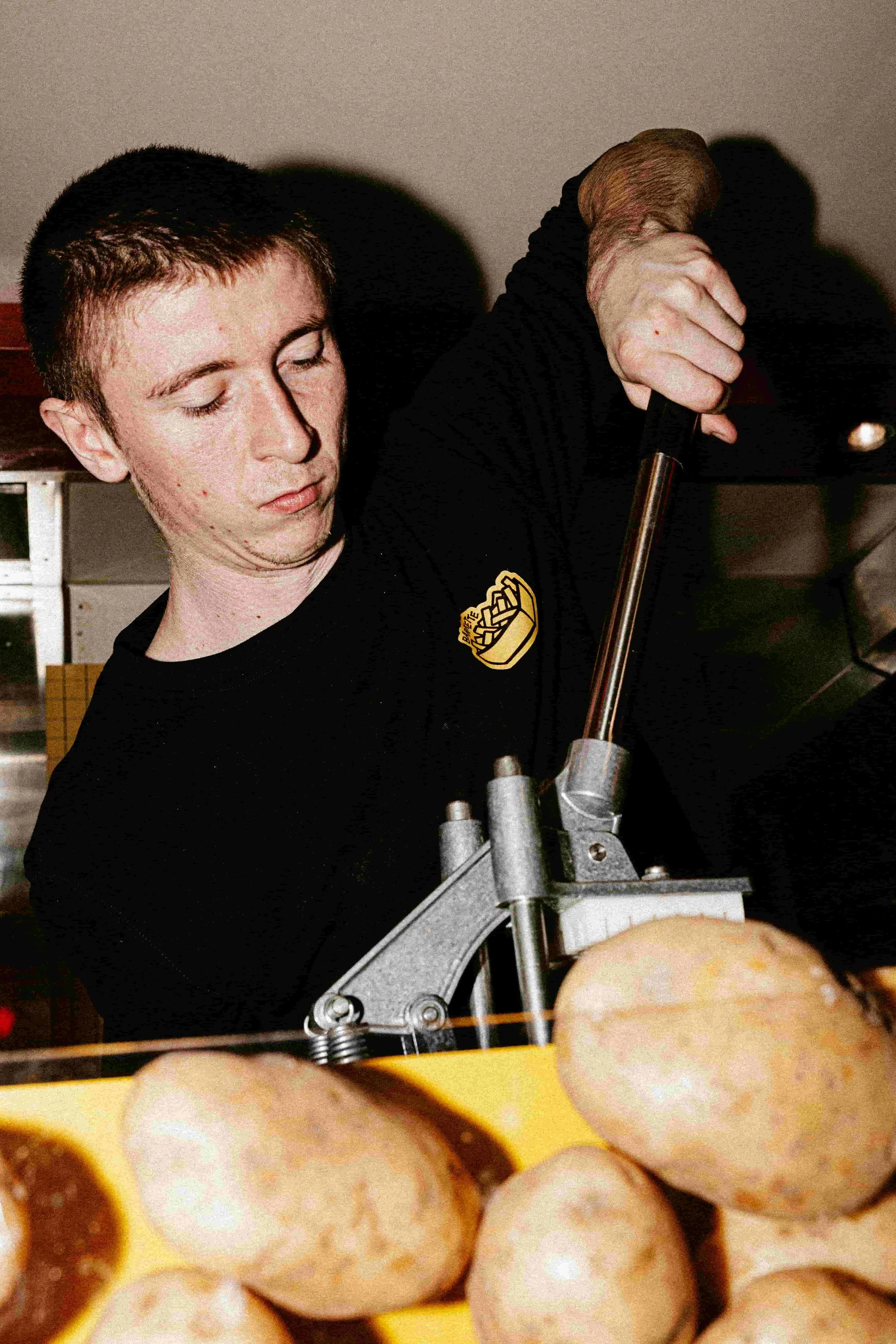 Un homme qui découpe des pommes de terre