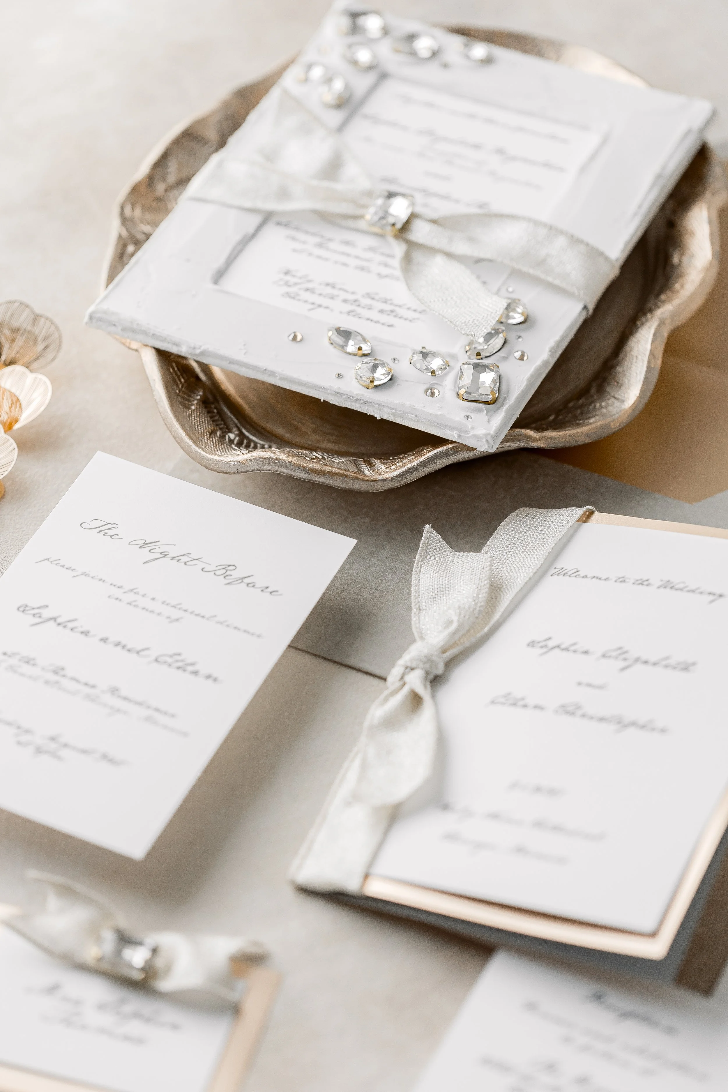 The suite captured from the side reveals the layered matte elements, ribbon tie, and dimensional rhinestones, highlighting its sculptural, heirloom-quality design.