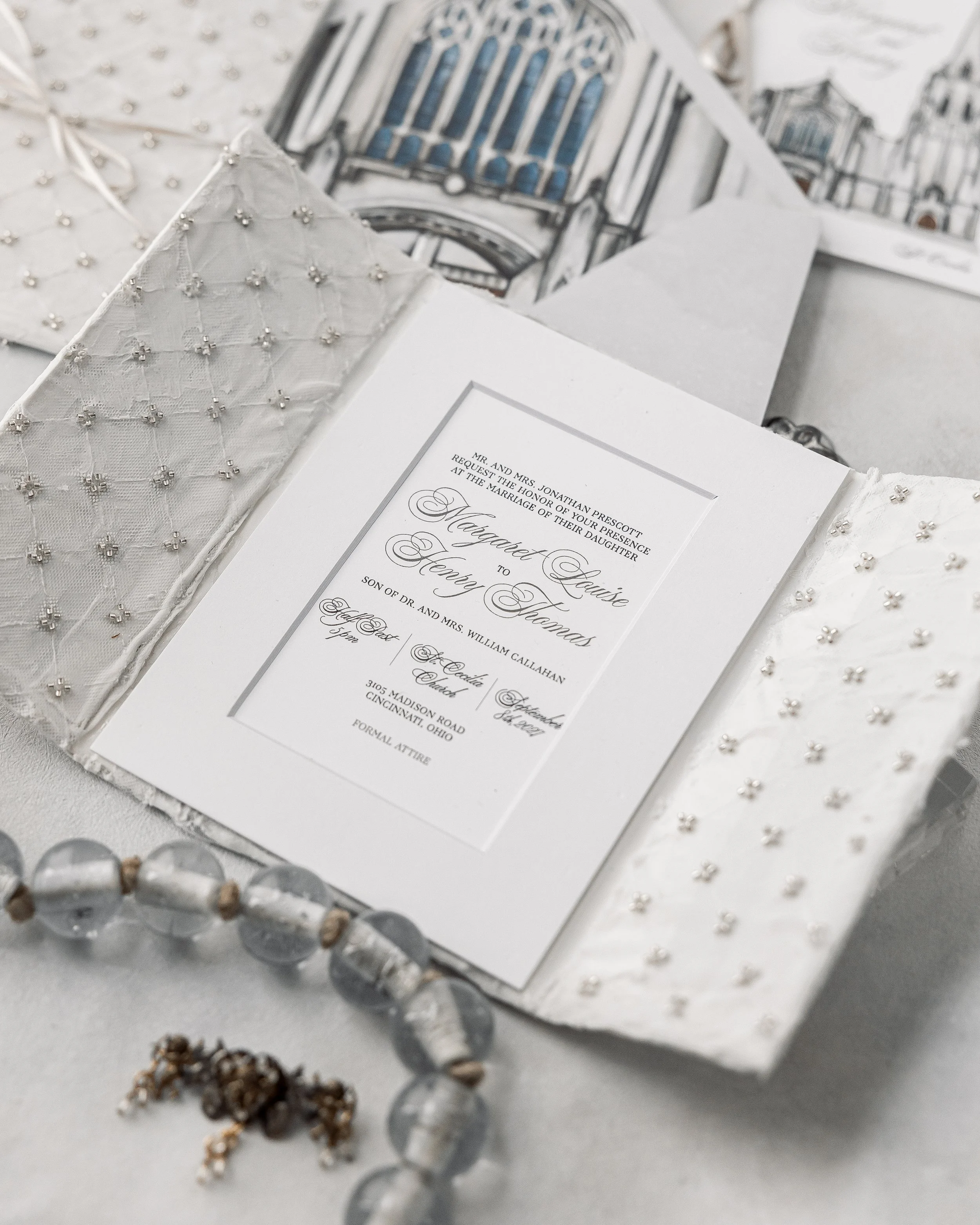 The gatefold opens to reveal textured silver-beaded fabric and soft, hand-painted watercolor details.