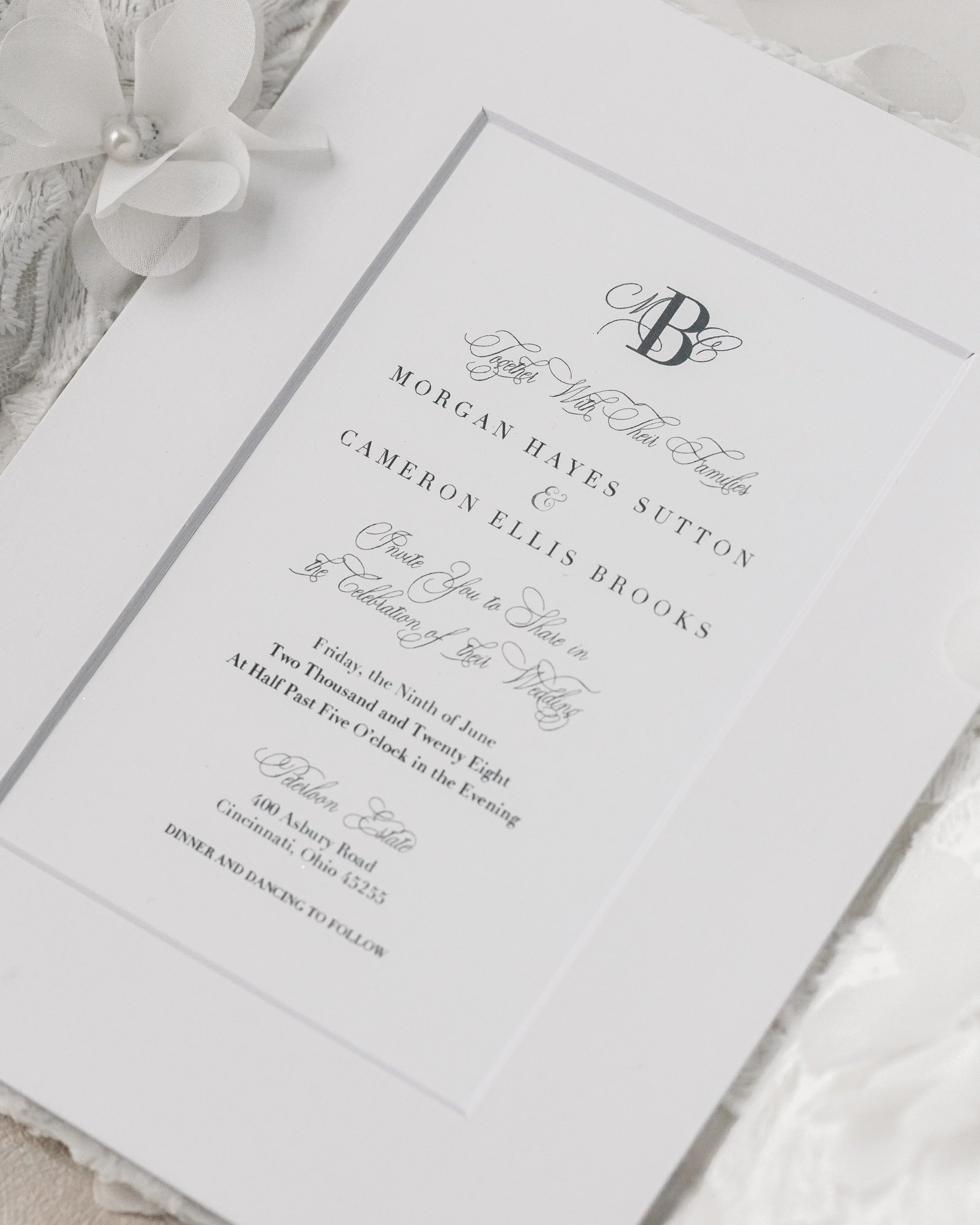 Crisp black digital printing rests beneath the white matte overlay, harmonizing with full-script type and monogram details for an elegant, readable presentation.