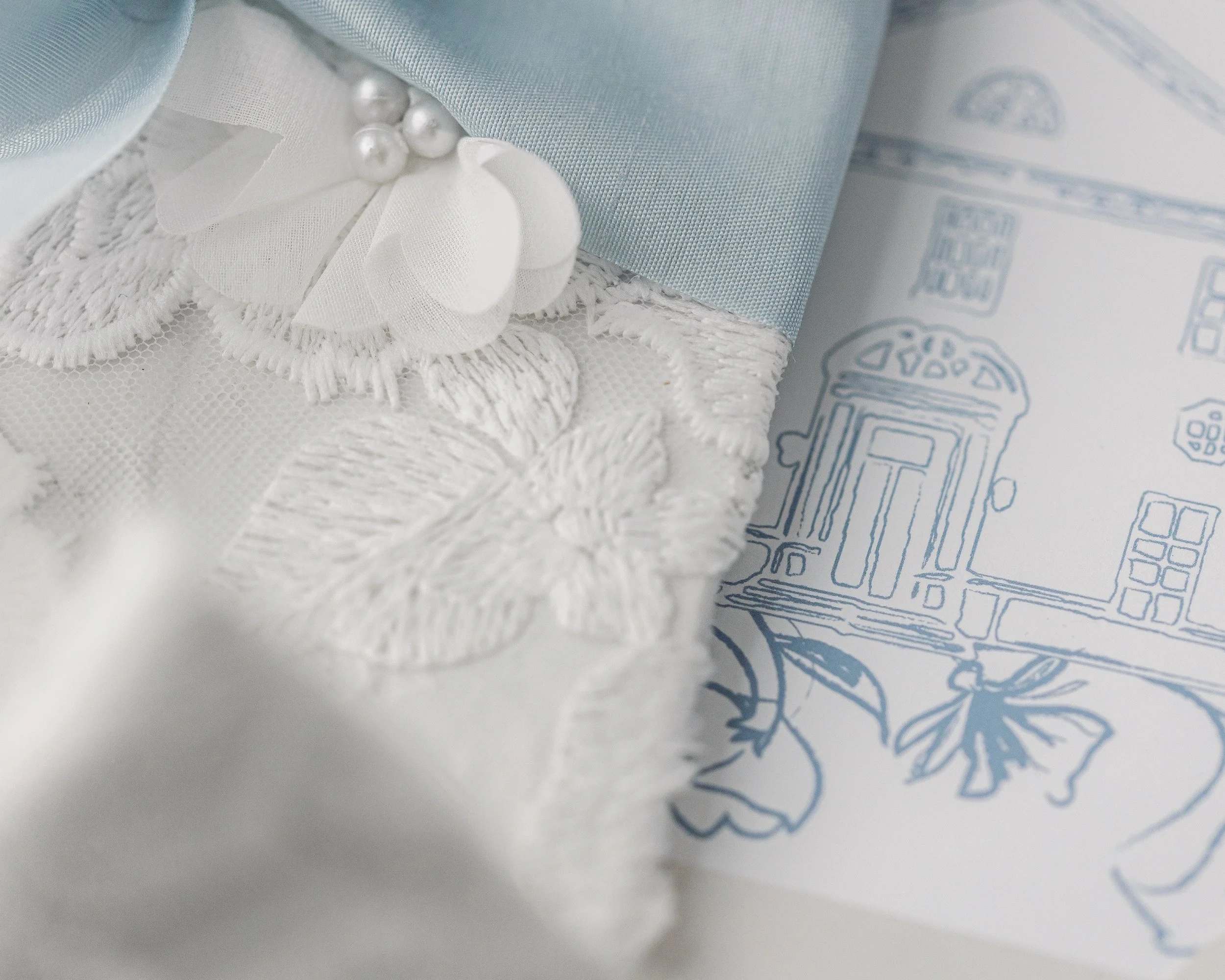 Fabric floral appliqués extend across the gates in three dimensions, creating depth and movement that invites touch as well as visual admiration.