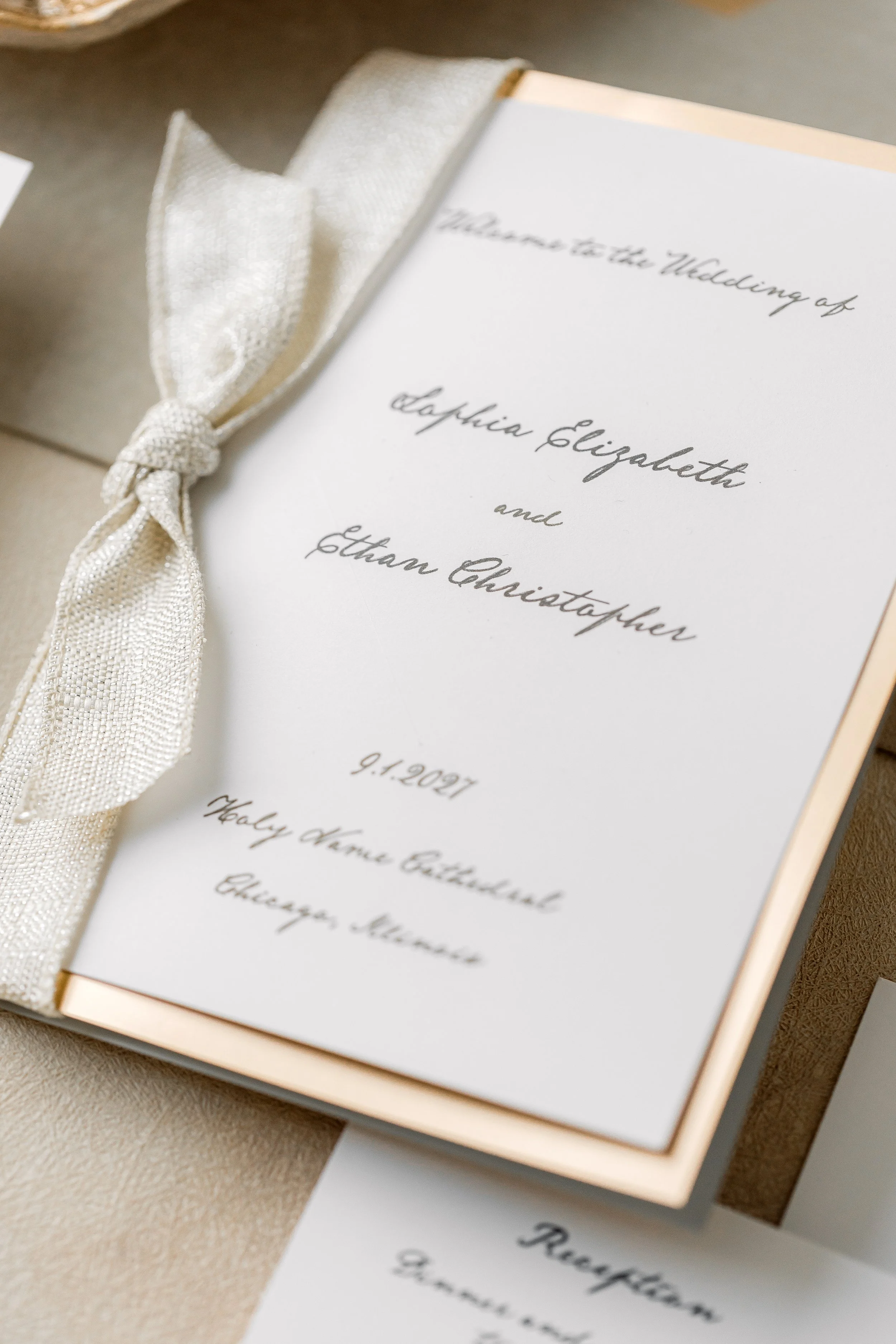 The coordinating ceremony program mirrors the envelope liner’s champagne metallic detail, carrying the suite’s design forward into the wedding day.