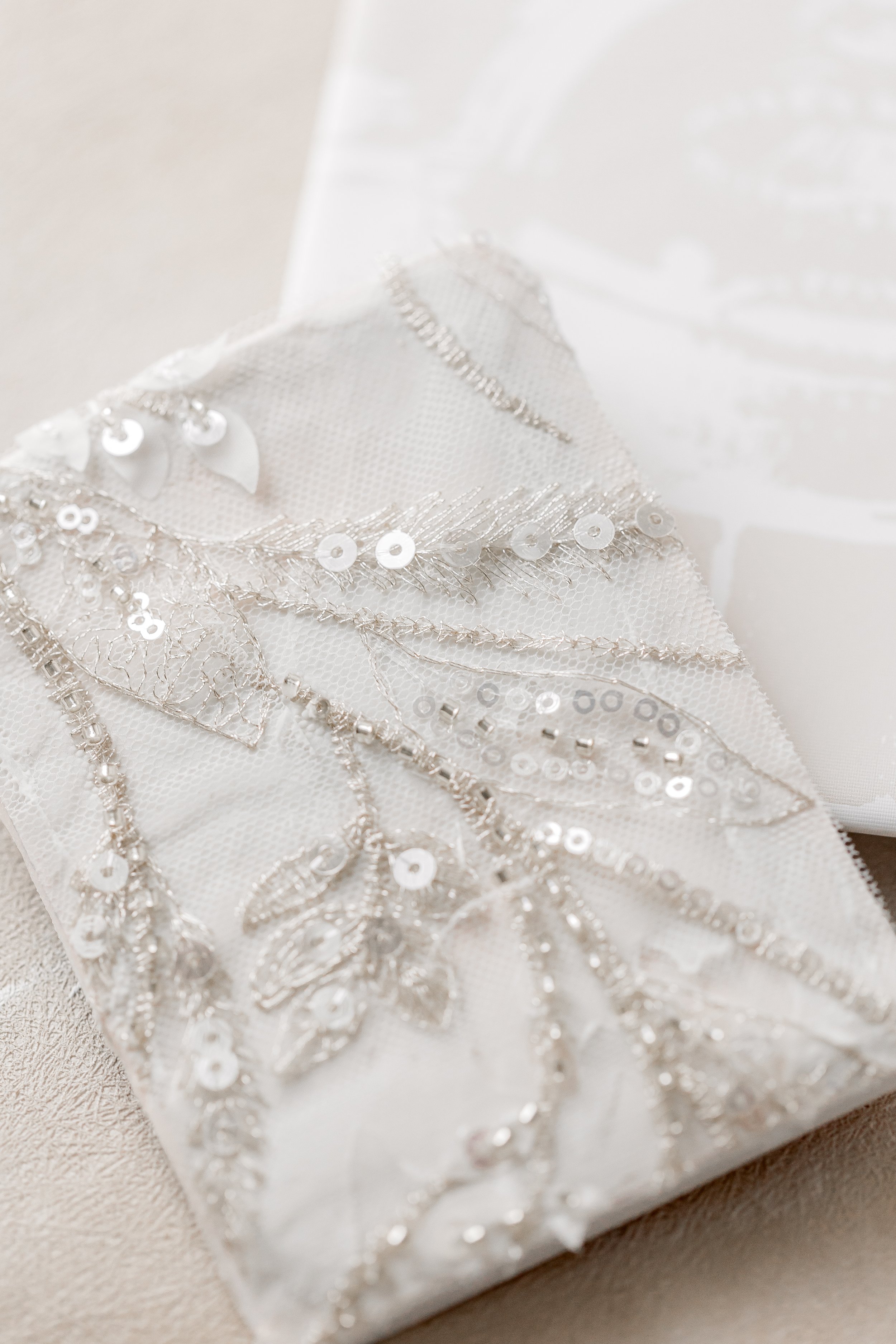 A coordinating vow book in textured champagne fabric, designed to mirror the suite’s embellishment and serve as a lasting heirloom beyond the wedding day.