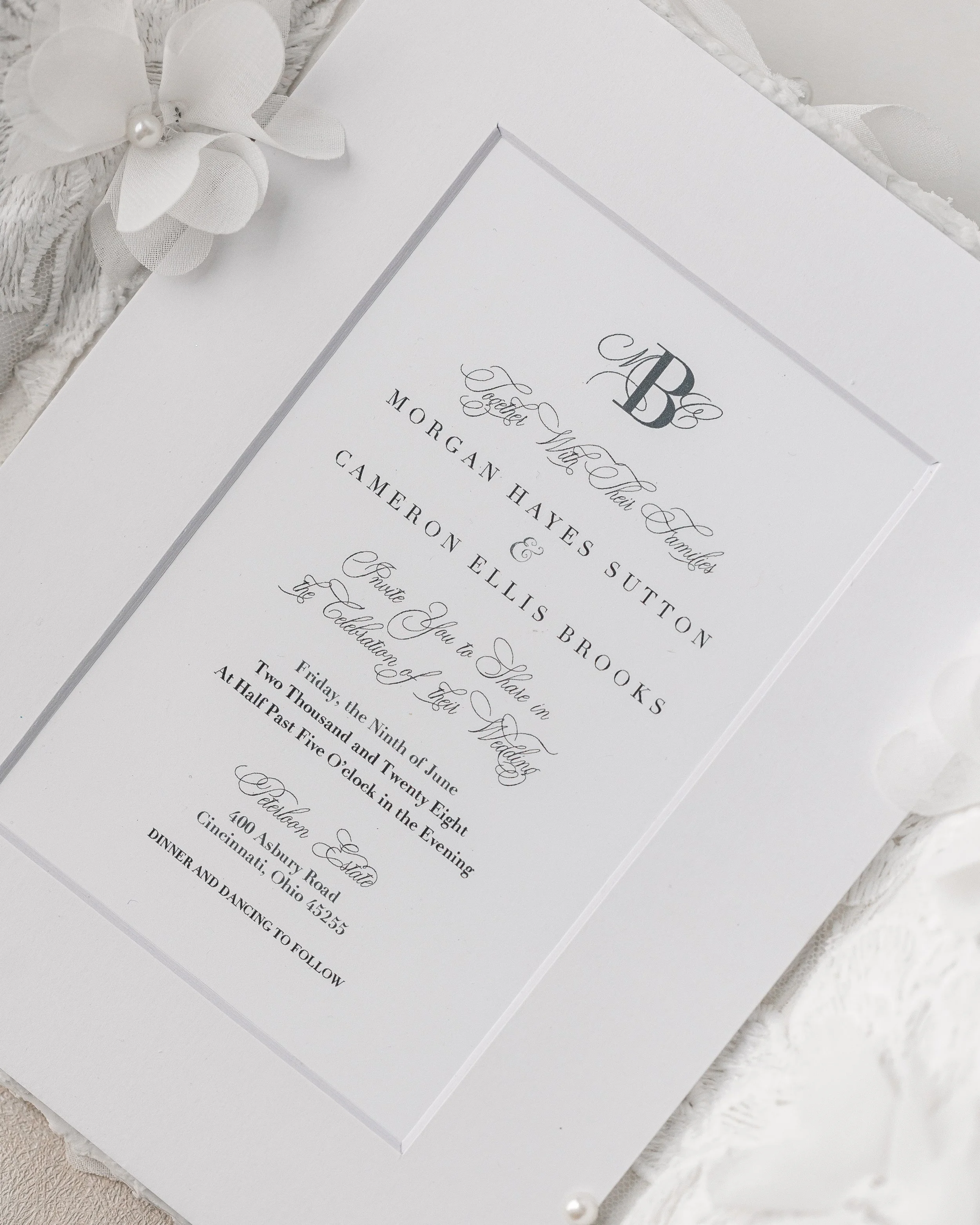 The combination of matte surfaces, sculptural gates, ribbon, and fabric florals evokes a sense of quiet ceremony, where every element interacts with light and shadow to create a multidimensional narrative.
