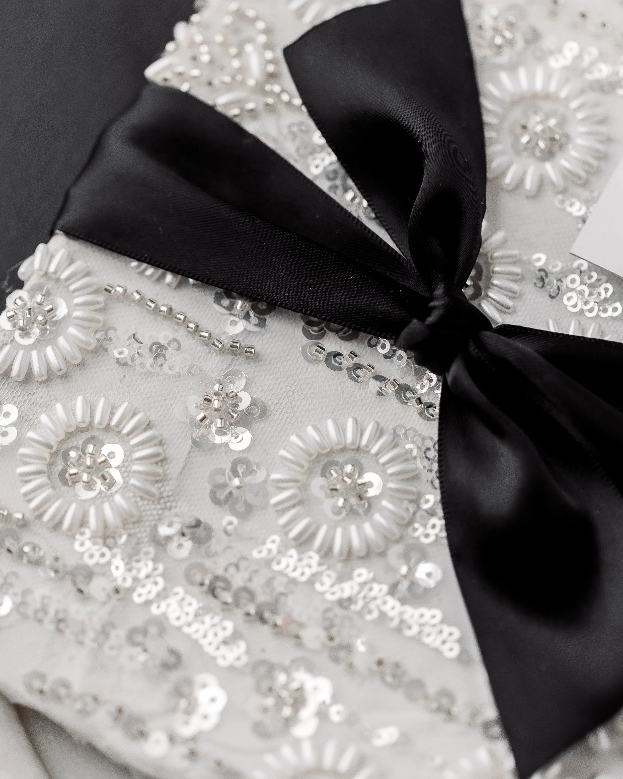 Every fold, embellishment, and ribbon twist is intentional, transforming a traditional invitation into an interactive, textural experience.