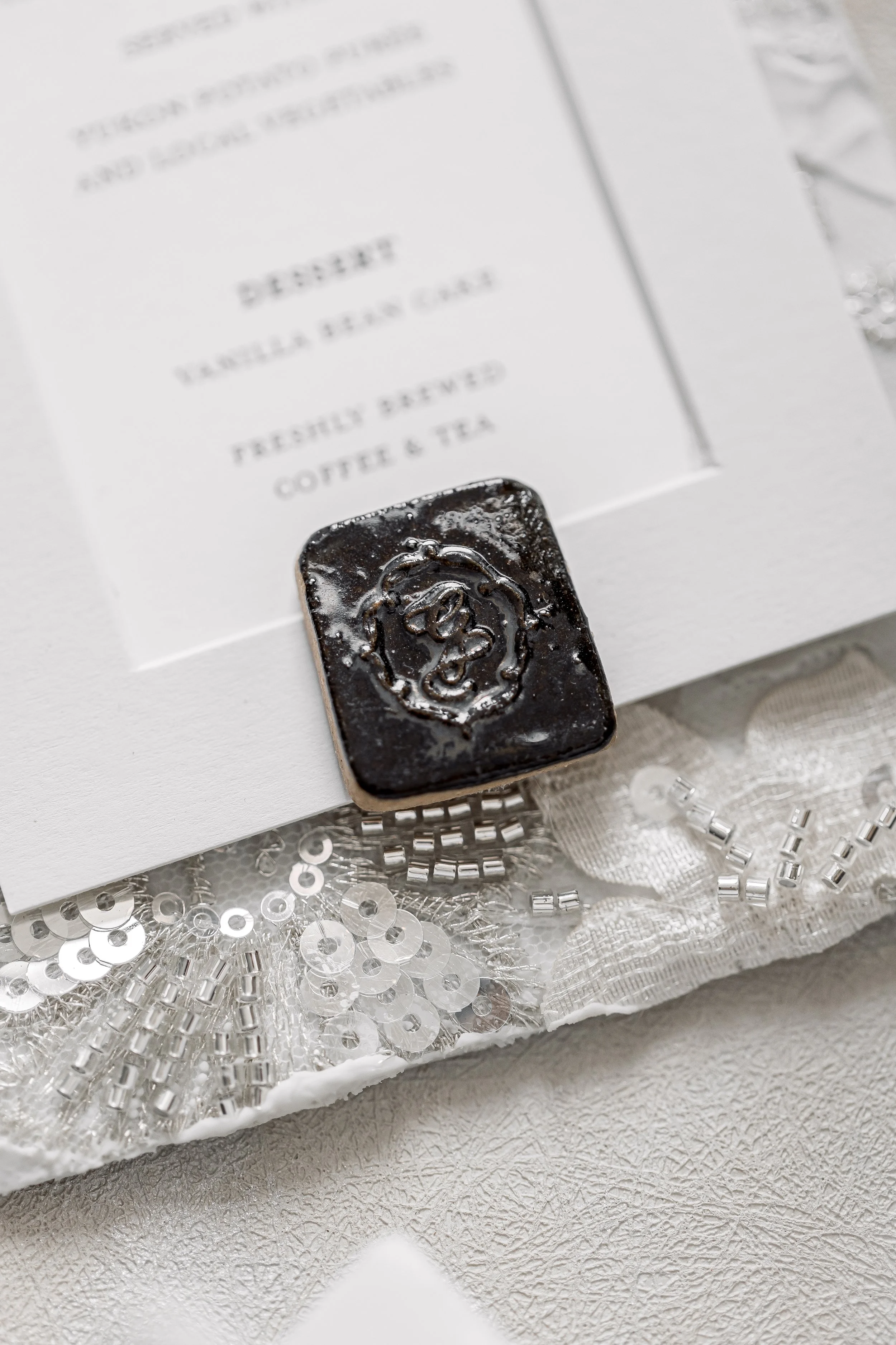 Handmade ceramic charms with the couple's monogram design.