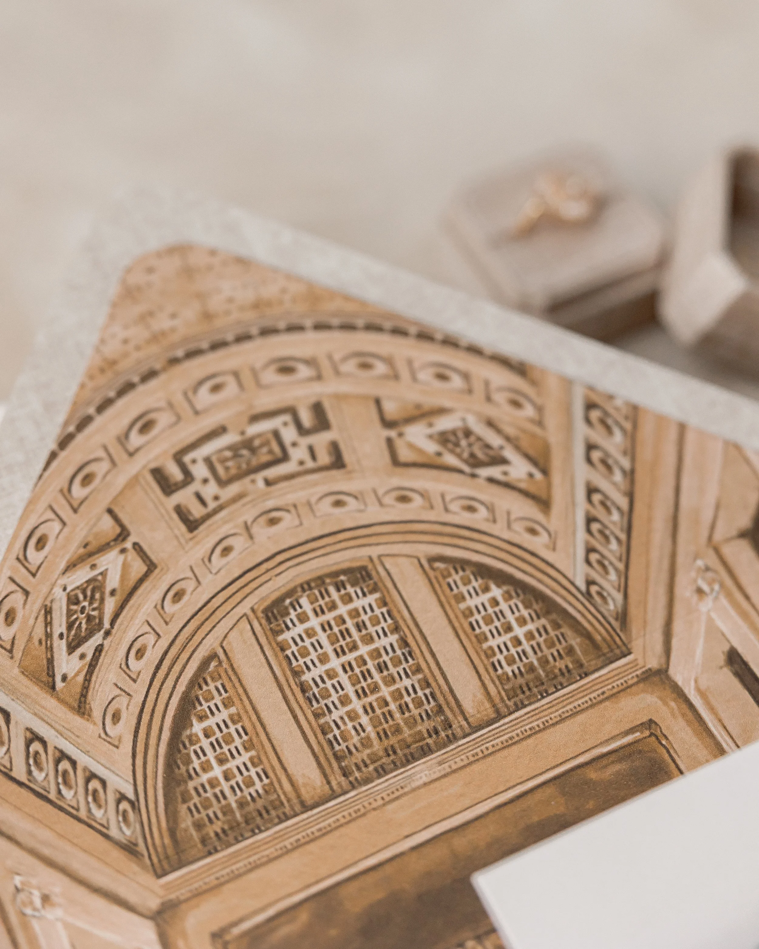 The beige envelope is lined with a hand-painted and digitized illustration of Renaissance Cincinnati Downtown in gold metallic tones, mounted on vinyl for subtle sheen and texture.