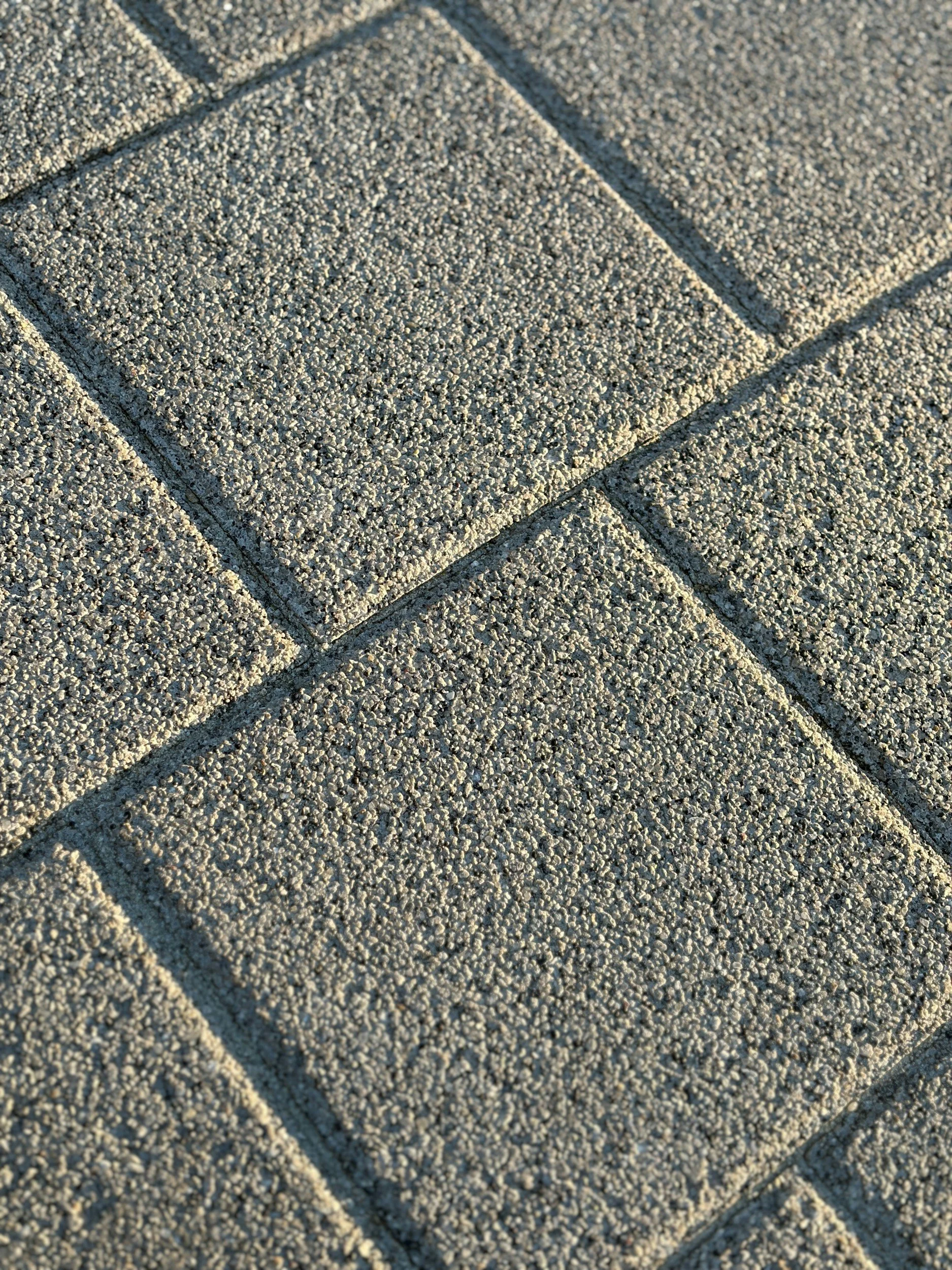 Close-up view of textured concrete pavers arranged in a grid pattern.