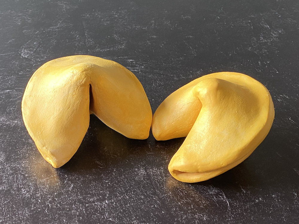 Two pieces of yellow durian fruit on a dark surface.