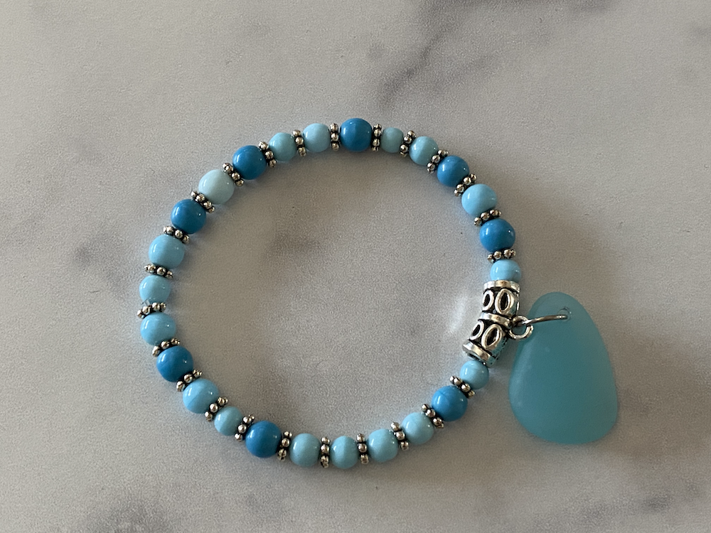 Beaded bracelet with blue and turquoise beads and a large turquoise teardrop-shaped charm.