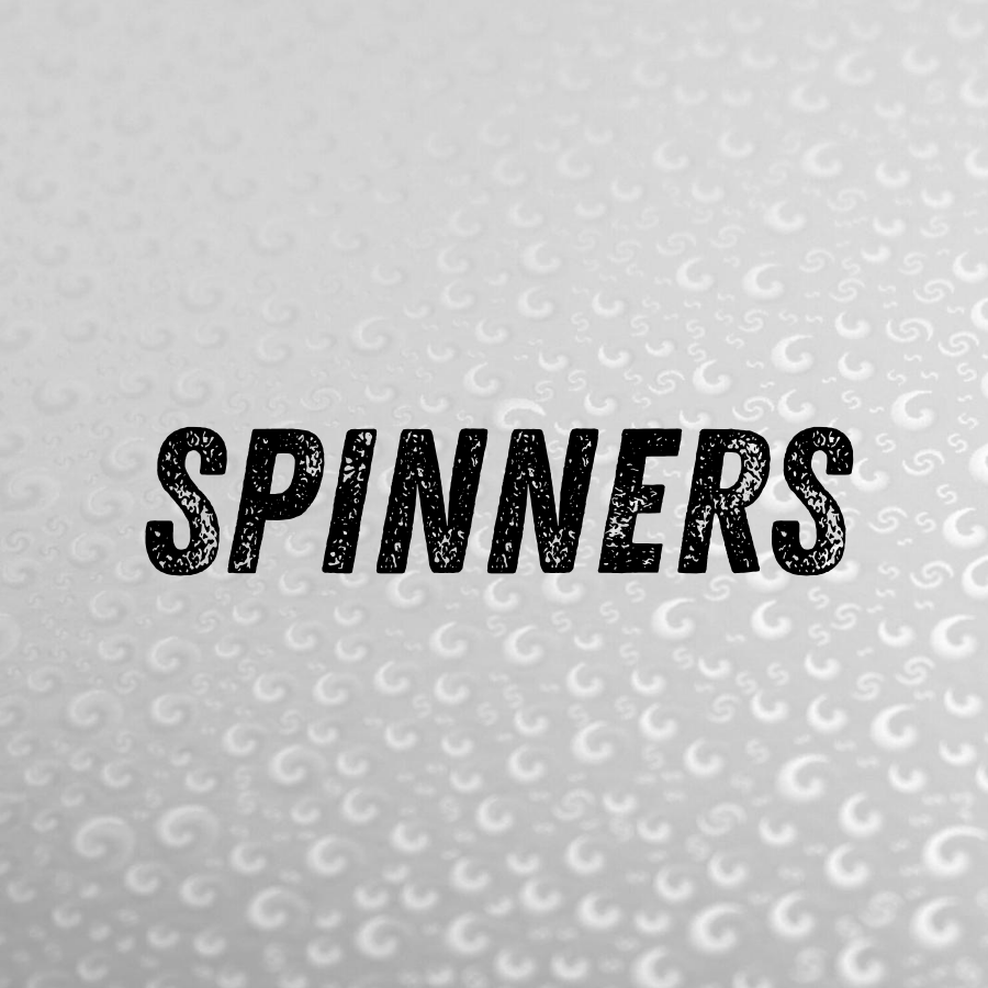 Close-up of a textured surface with the word 'SPINNERS' in bold black letters at the center.