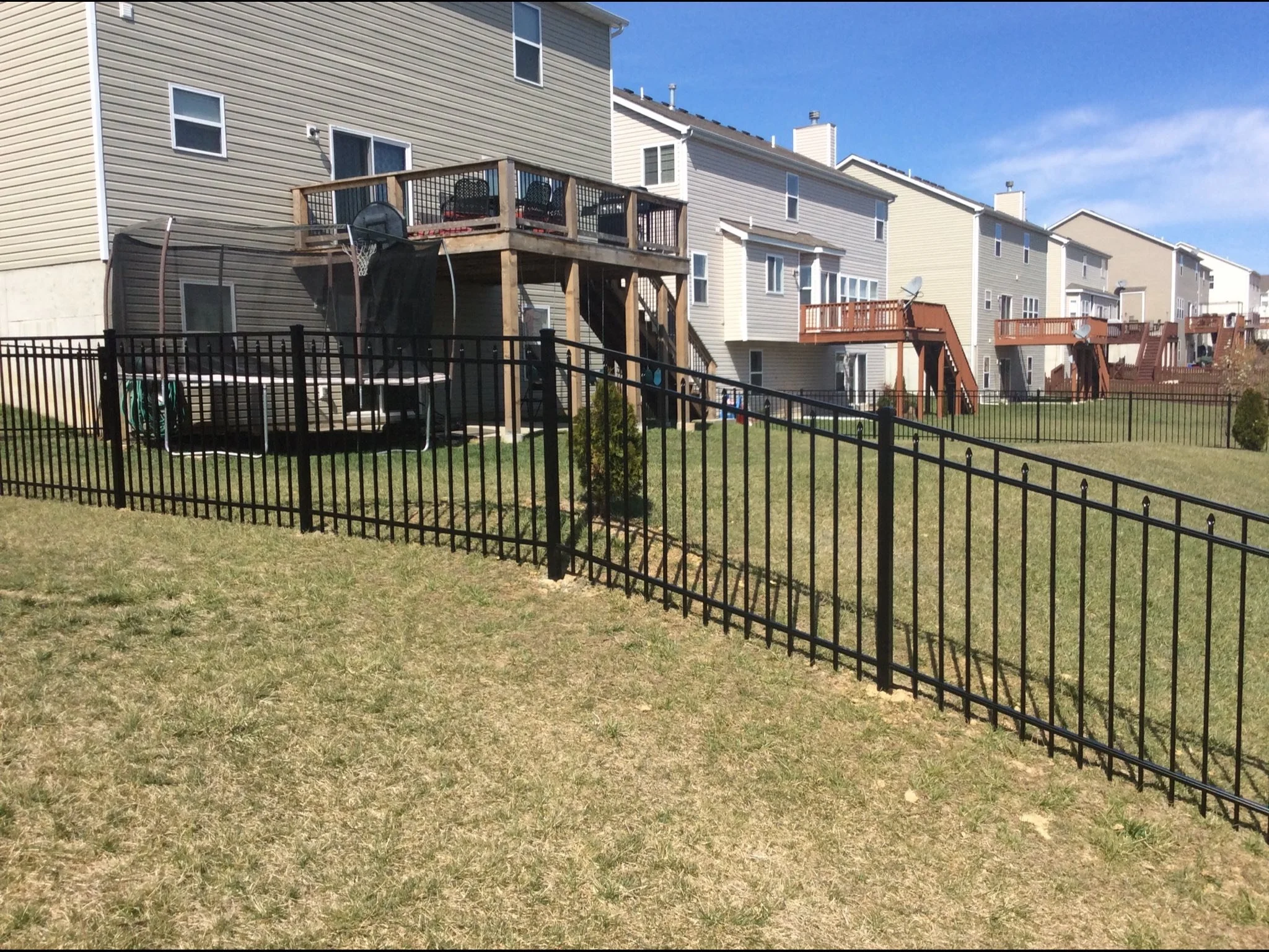 black ornamental aluminum fence in backyard with hill