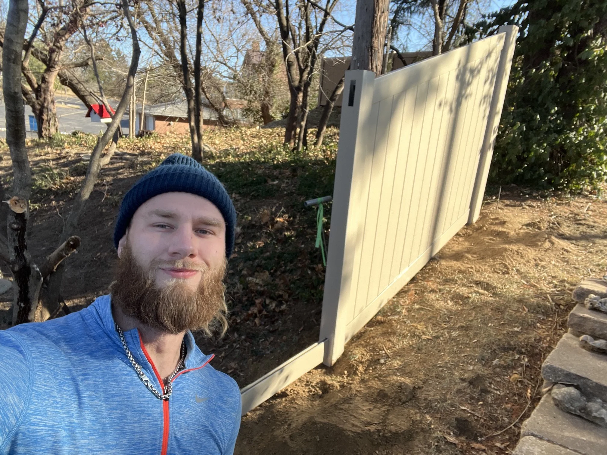 Tan vinyl fence construction in progress in St. Charles, Missouri next to Lindenwood University