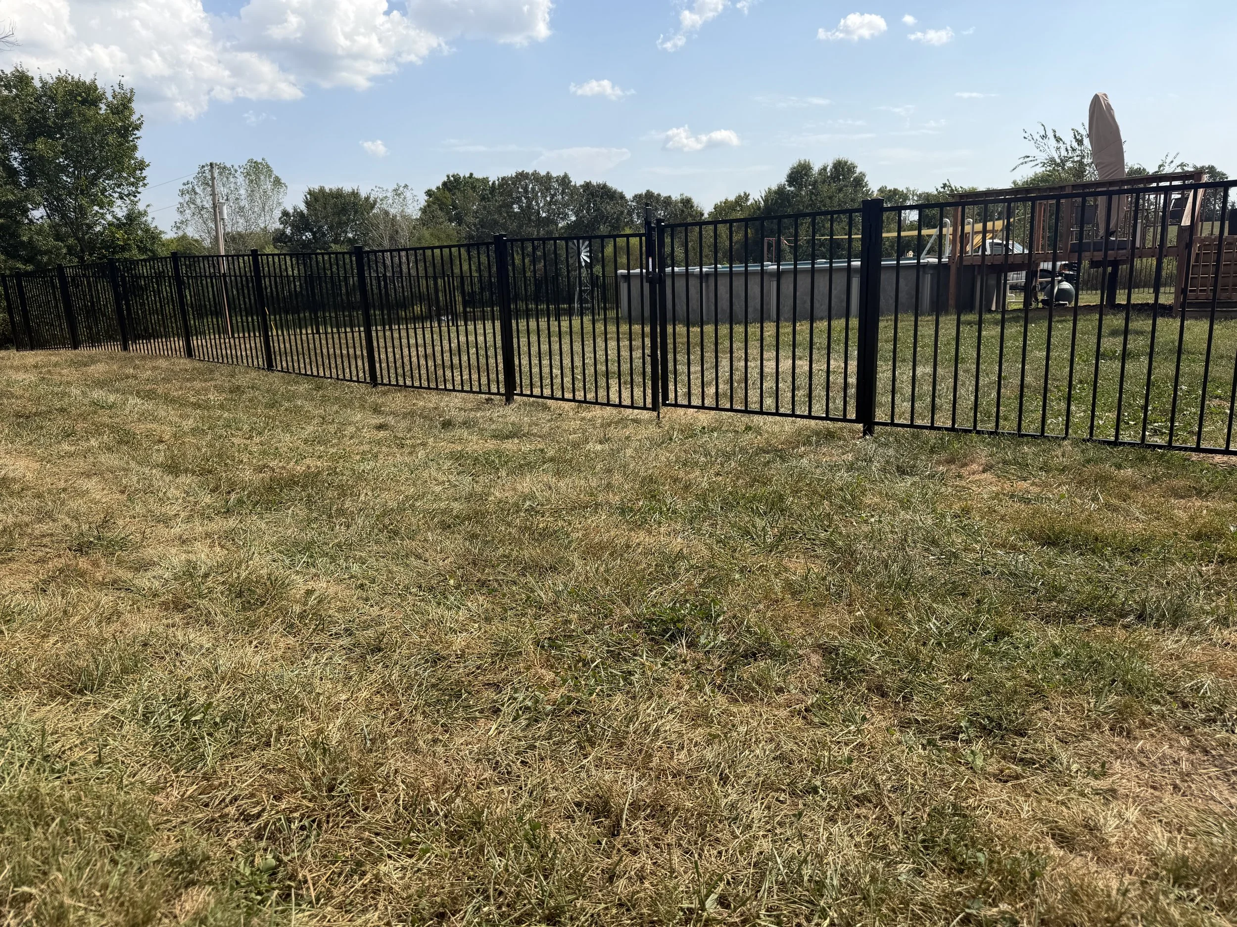 Black two-rail aluminum fence along the yard at a rural Wentzville, Missouri home