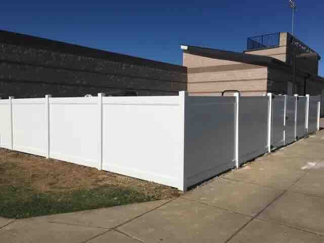 white vinyl privacy fence around a brick building
