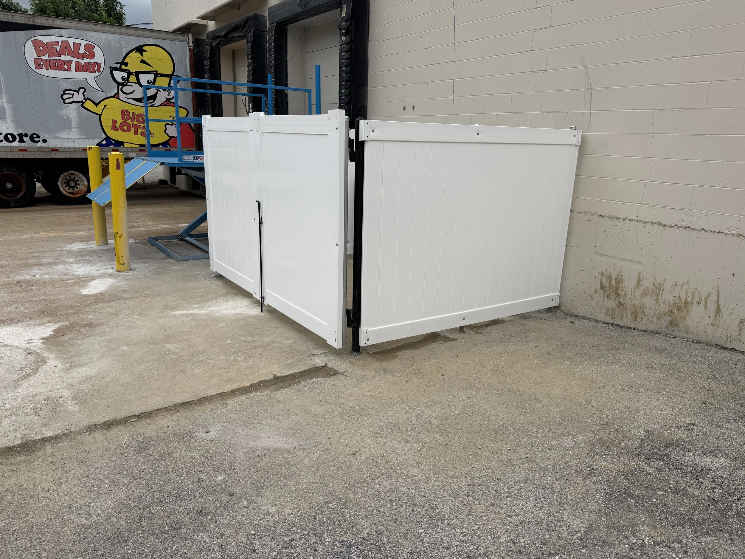 White commercial trash enclosure with privacy panels and gates