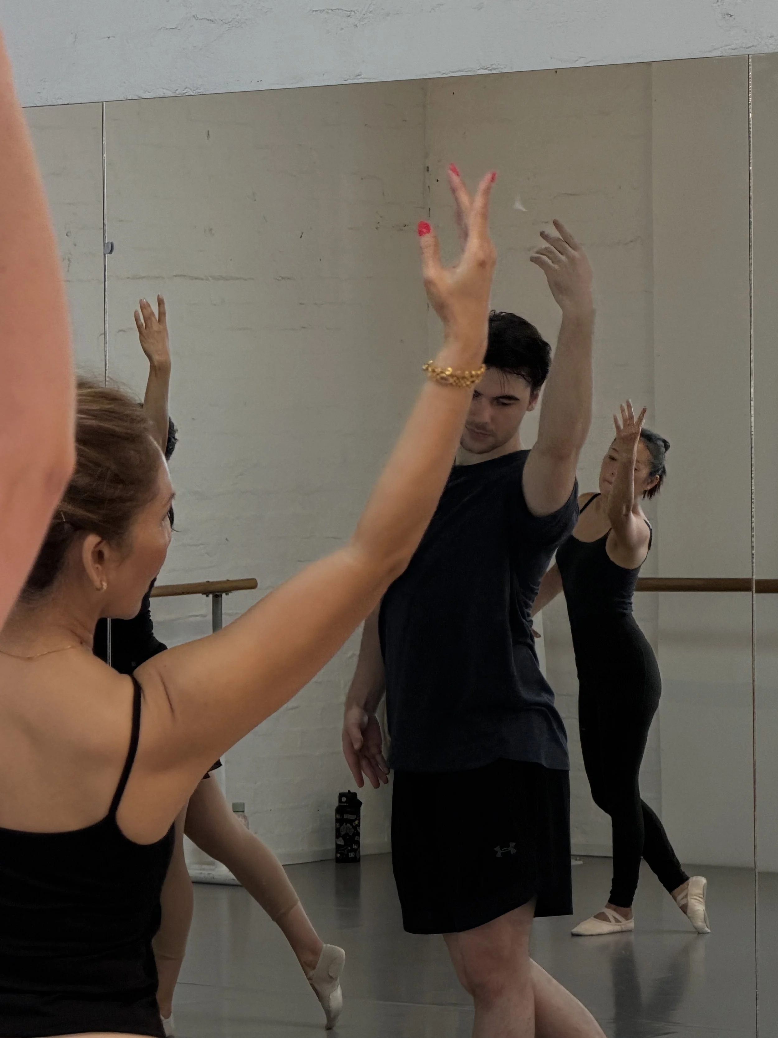 Ballet dancers practicing in a dance studio with ballet barres.