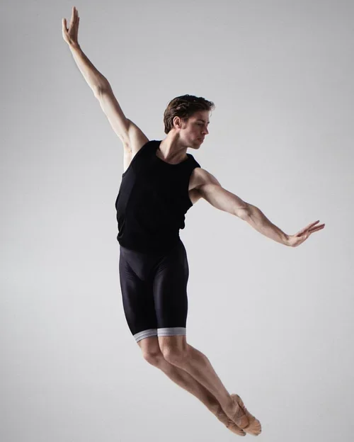 Ty King-Wall in athletic attire performing a dance move against a plain background.