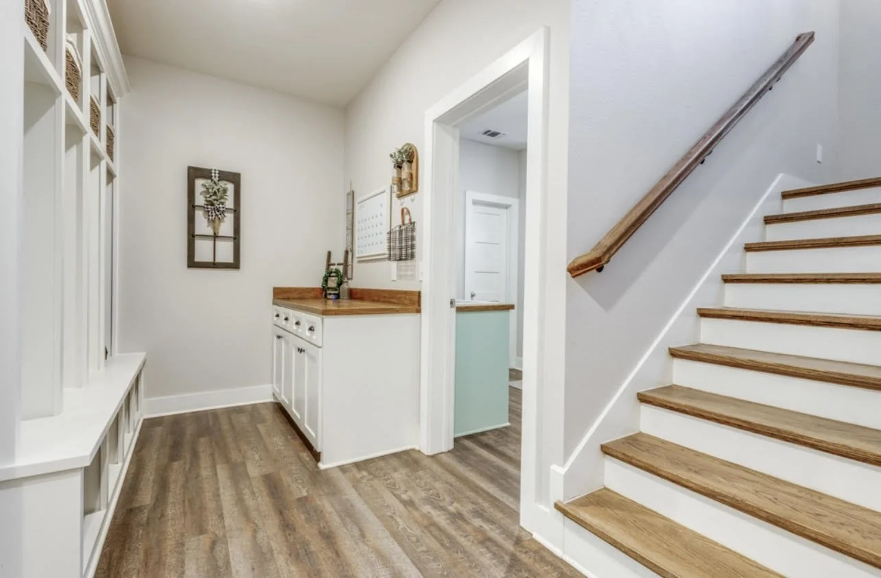 Custom home mudroom with built-in lockers, cabinetry and stained wood stair treads