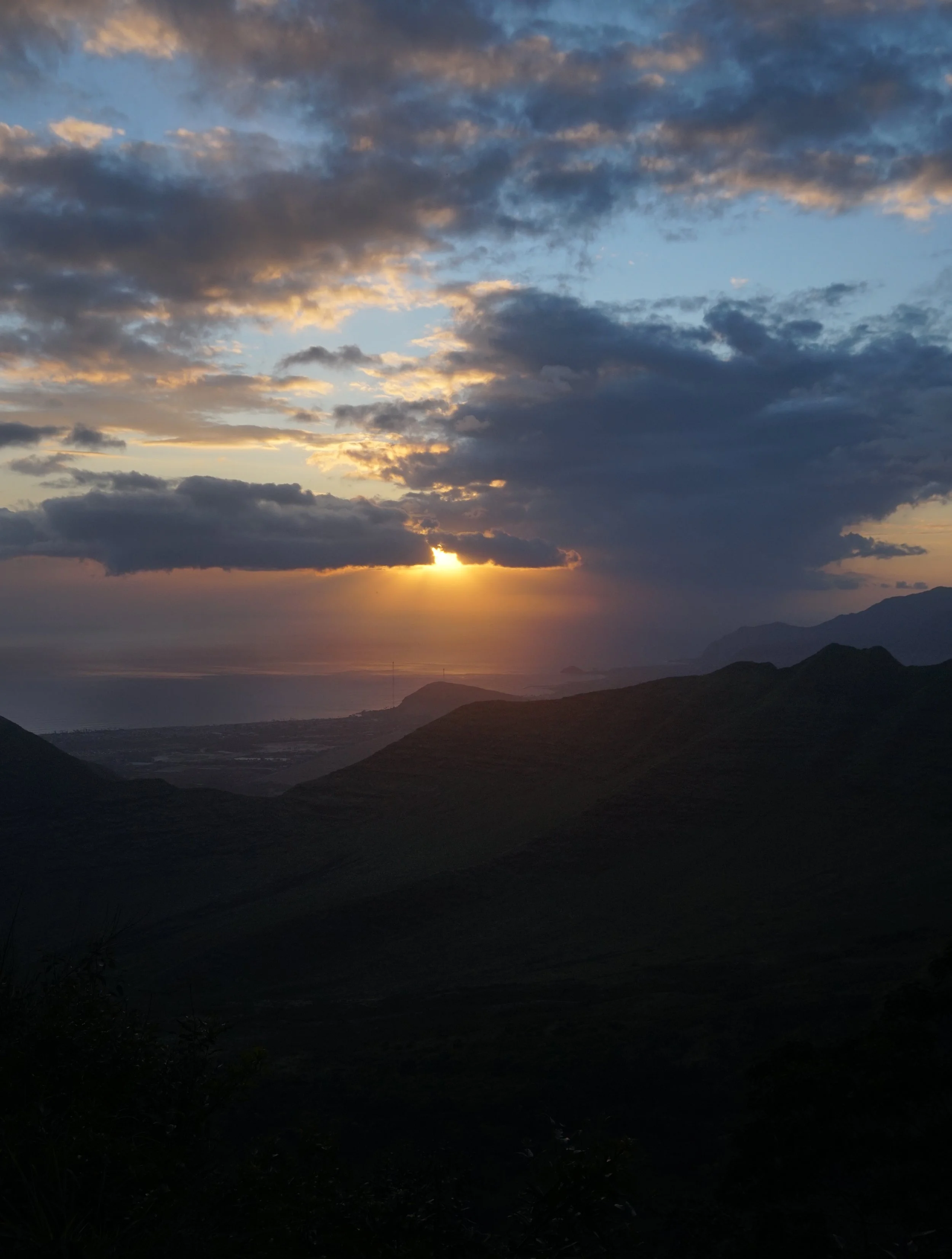 Sunset over mountains with a partly cloudy sky. Oahu Family Therapy, Honolulu, HI. Providing Individual, Couples, Pre-marital, and Family therapy.