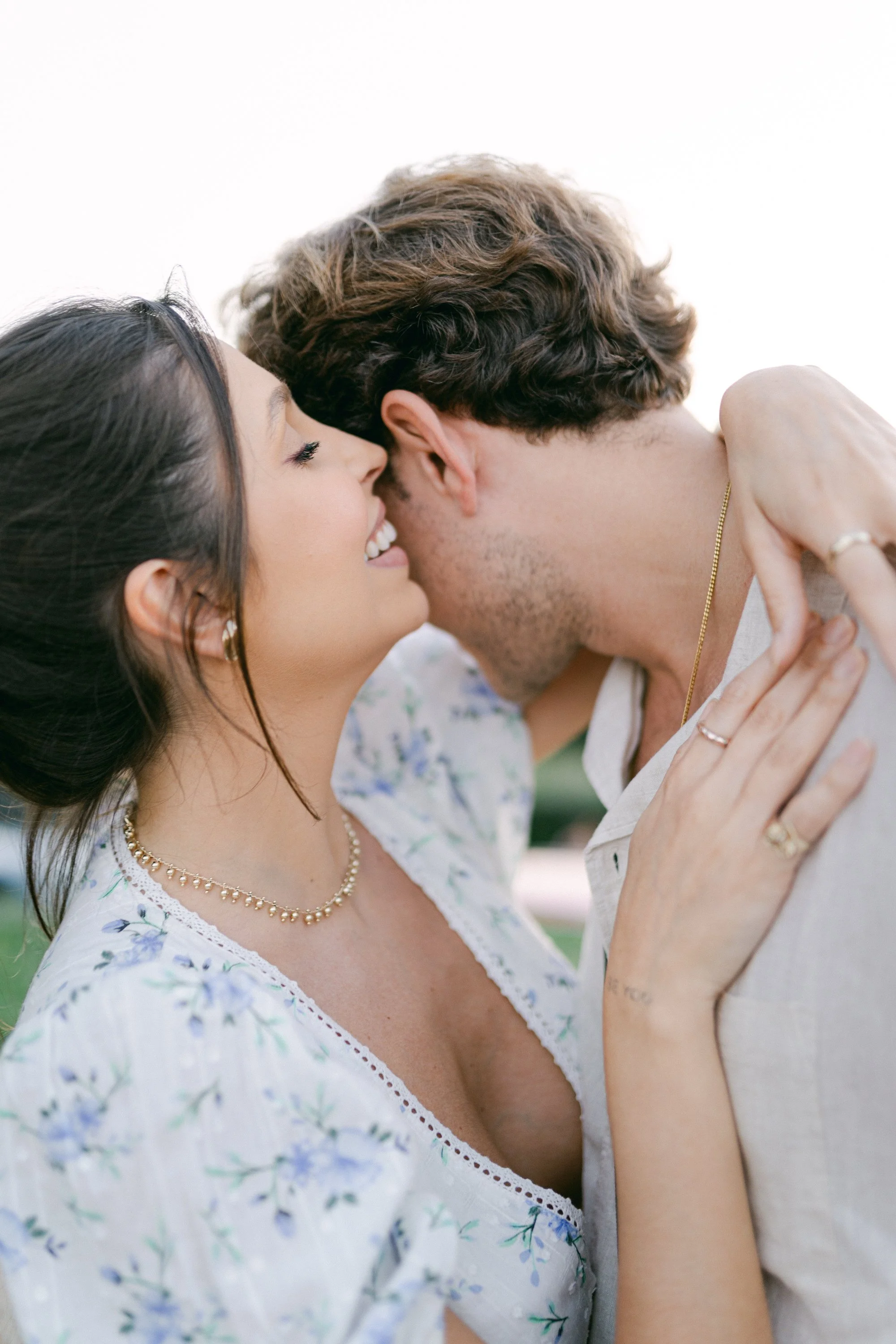 Un couple qui s'embrasse tendrement, avec la femme souriante et les yeux fermés.