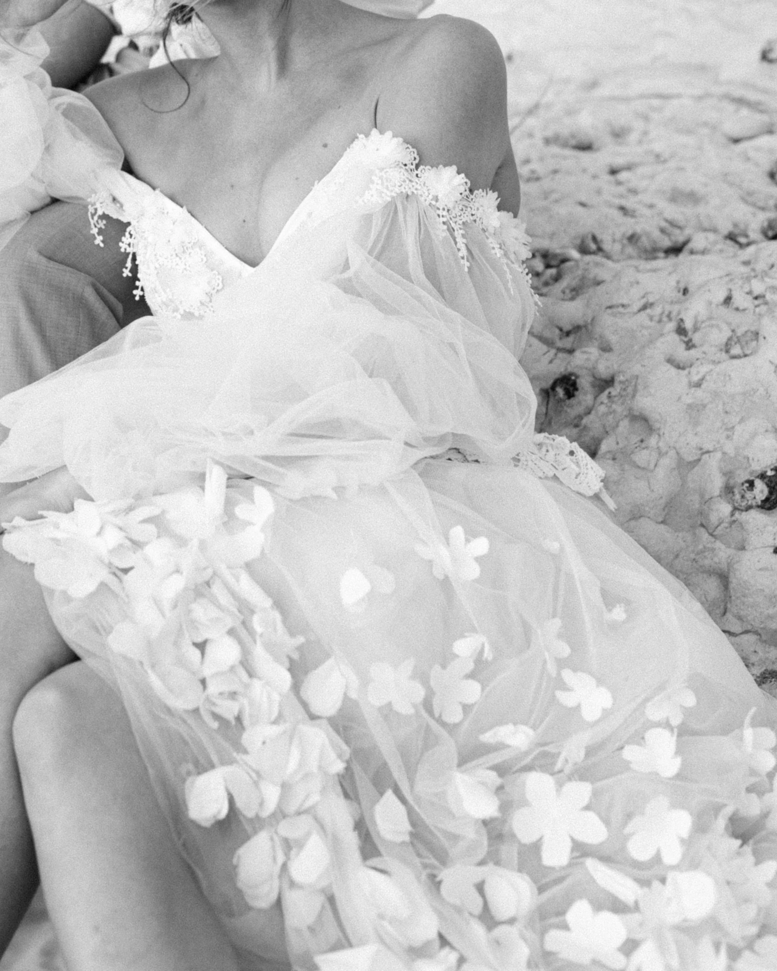 Une femme en robe de mariée repose sur le sable, image en noir et blanc
