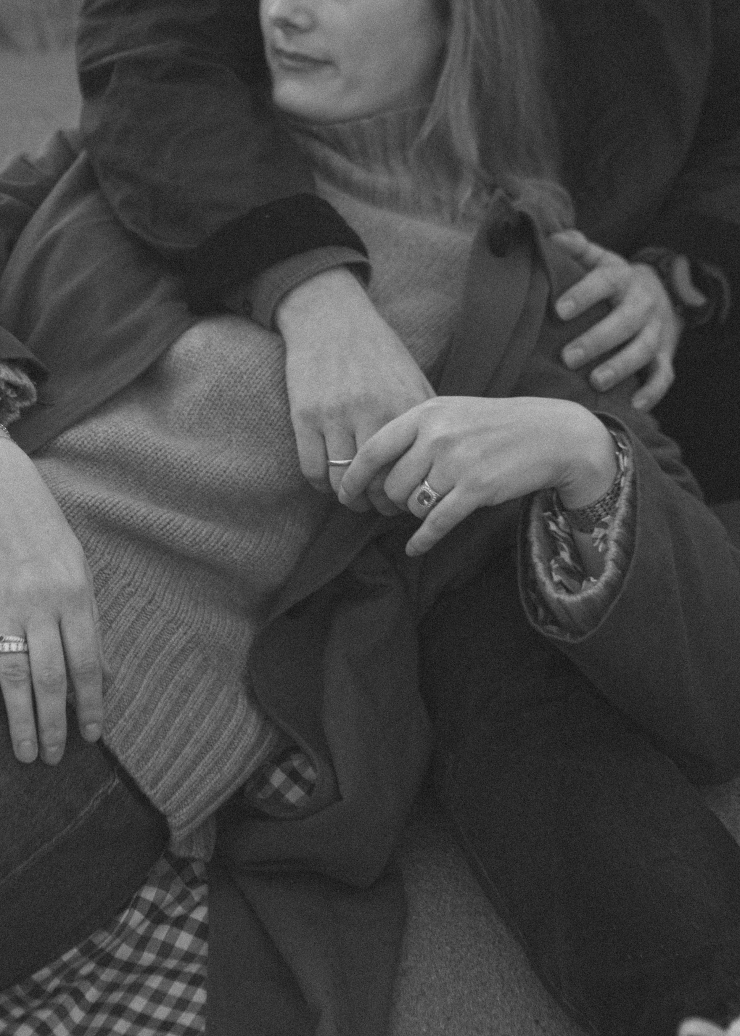 Trois personnes se tiennent par la main et se tiennent dans une position câline, symbolisant une proximité ou une relation affectueuse.