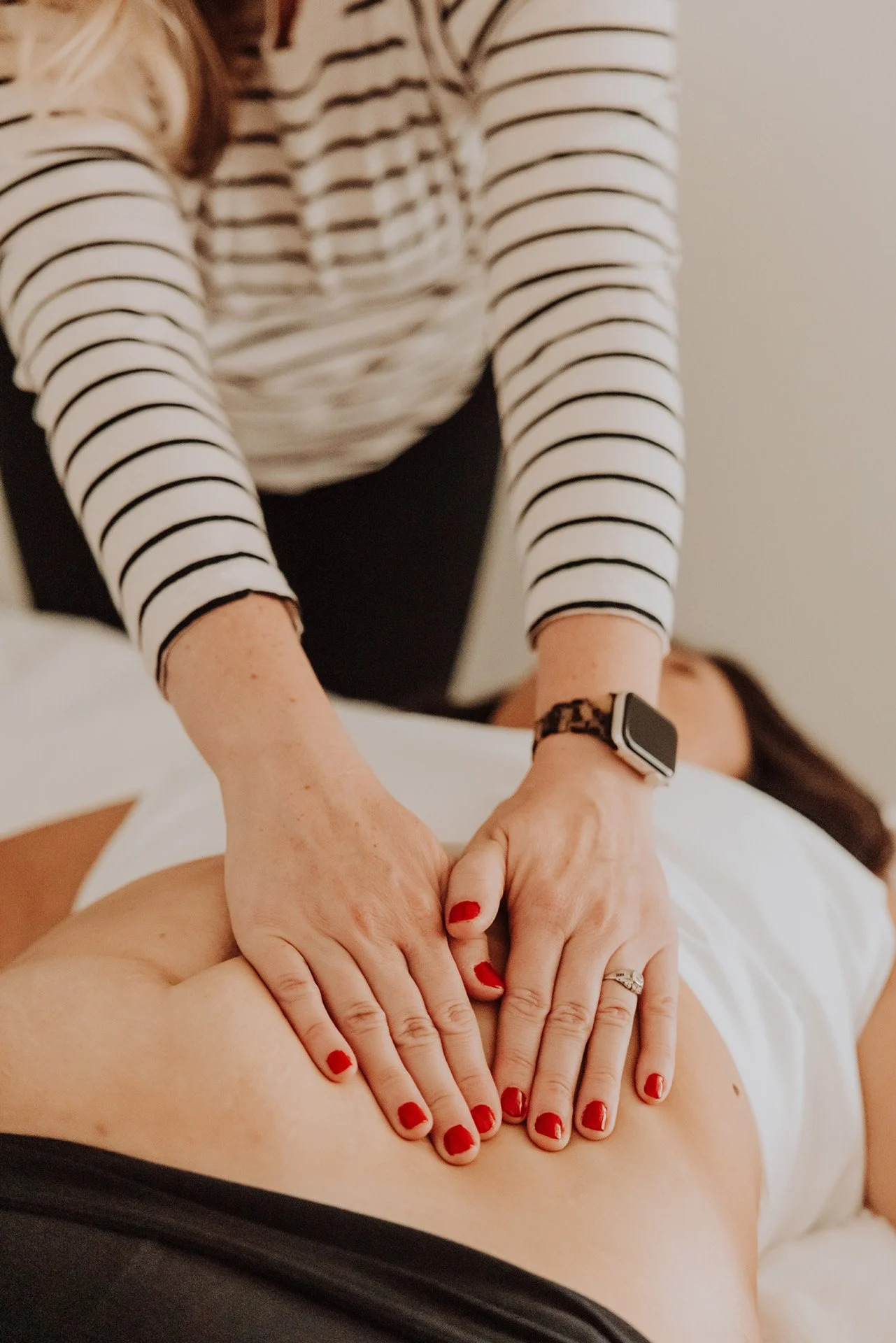 Janelle Kloske, OT, detail shot of abdominal massage therapy, her hands on a client's abdomen