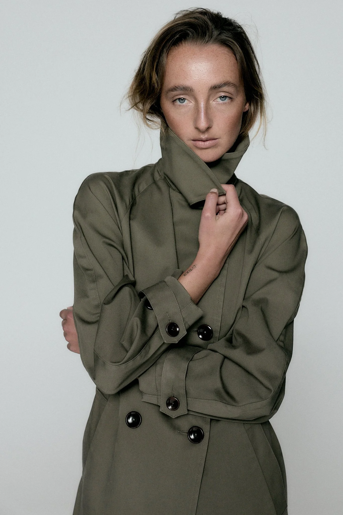girl in trenchcoat in photo studio