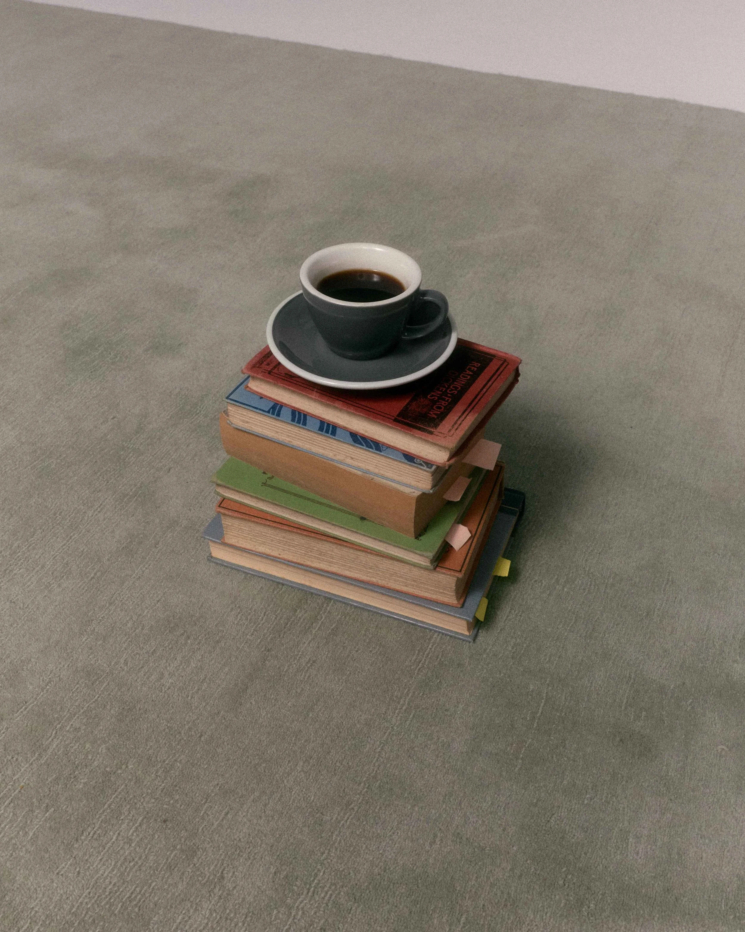 Stack of books with a coffee cup on top, all placed on a Baya rugb.
