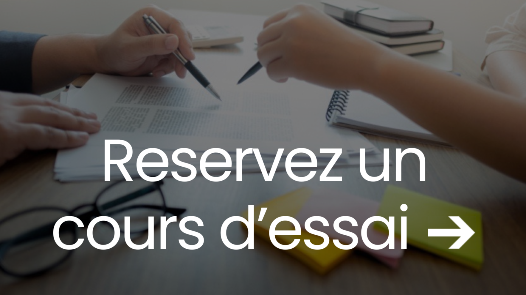 Une table de bureau avec deux personnes en train de signer des documents, accompagnée de carnets, d'une paire de lunettes et de notes autocollantes. Sur l'image, en surimpression, le texte 'Réservez un cours d'essai' avec une flèche.