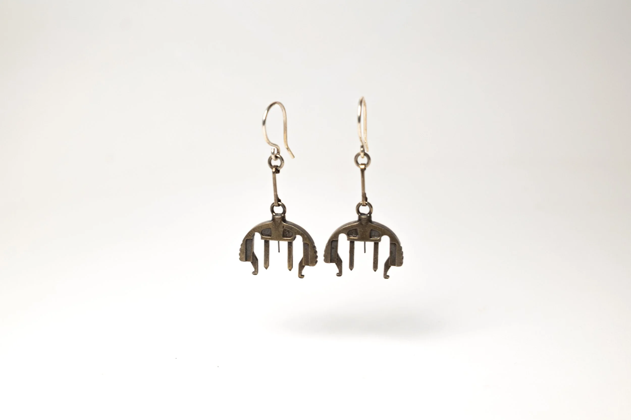 Bronze and silver earrings with infusion sets dangle design on a plain white background.