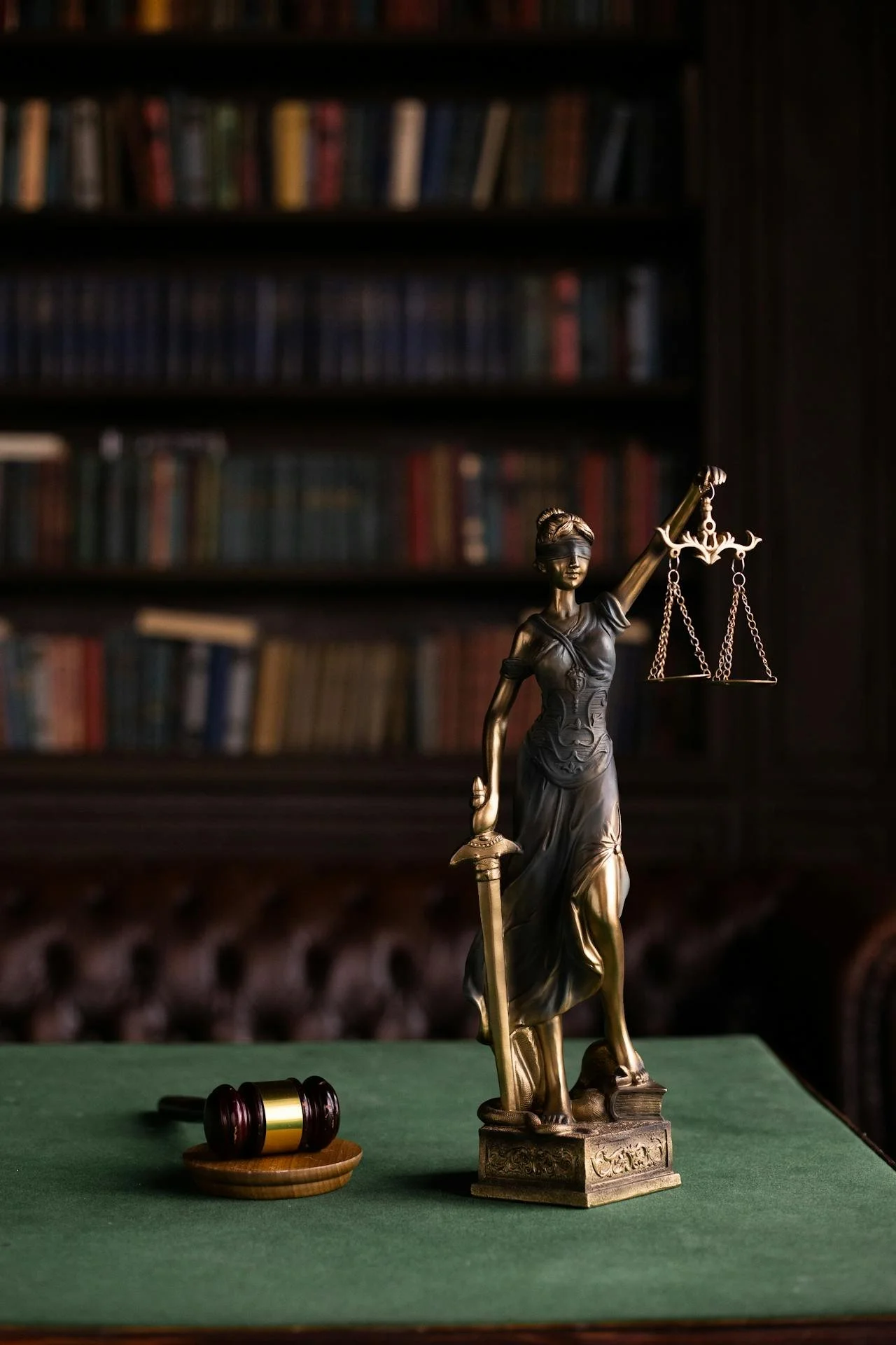 Lady Justice statue and judge’s gavel in a law office library, representing legal services at Diviney & Wilt