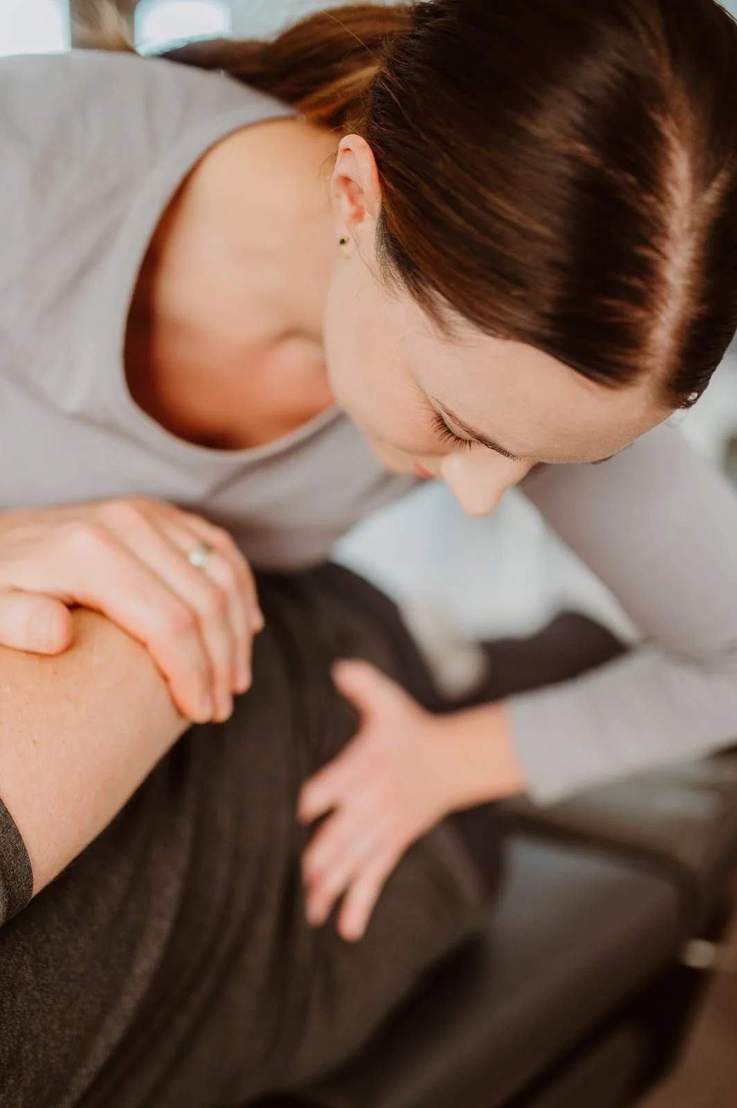 A woman receiving a massage on her shoulder from a massage therapist at Creekside Dynamic Health.