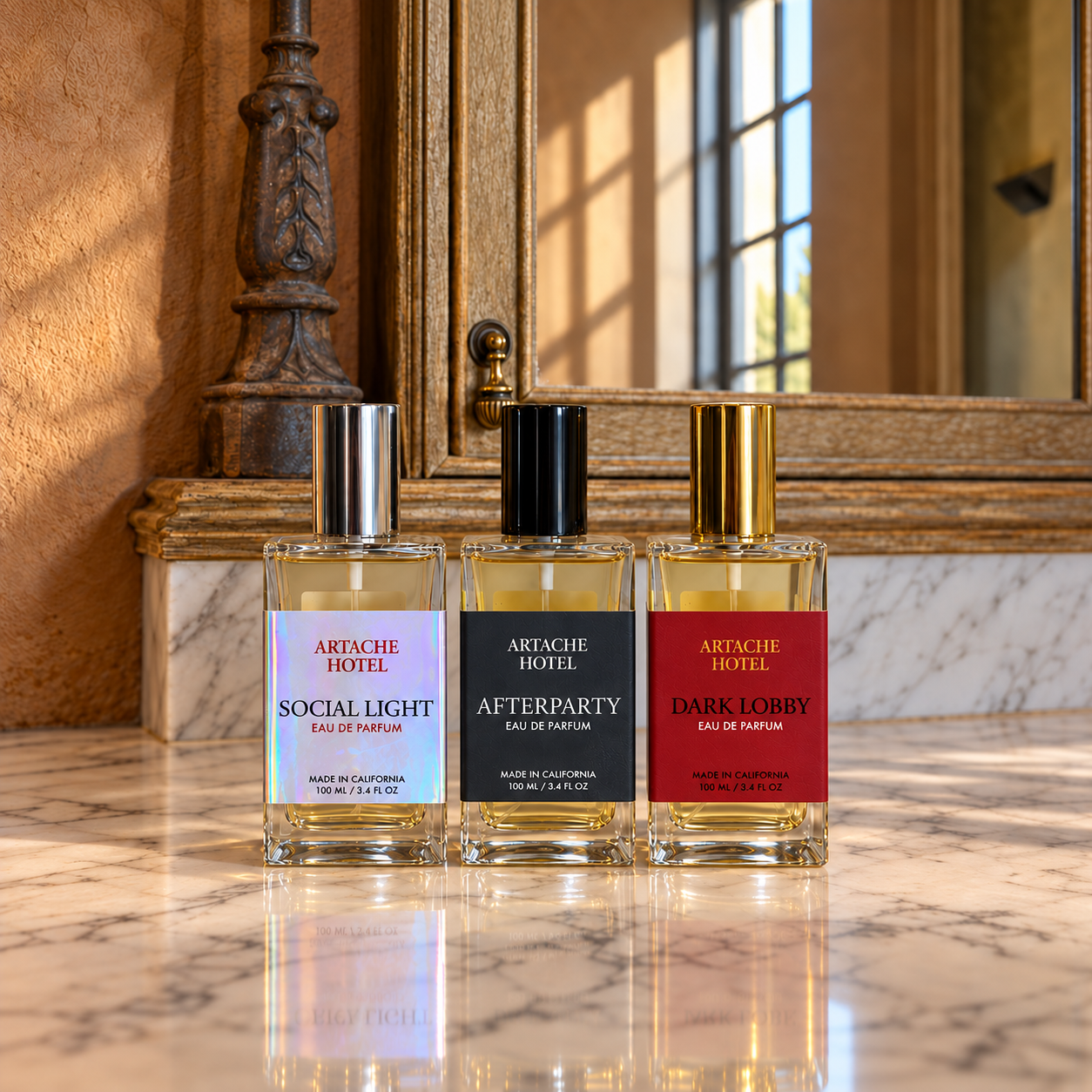 Three bottles of Artache Hotel perfume on a marble countertop, labeled Social Light, Afterparty, and Dark Lobby, with ornate wood and mirror background.