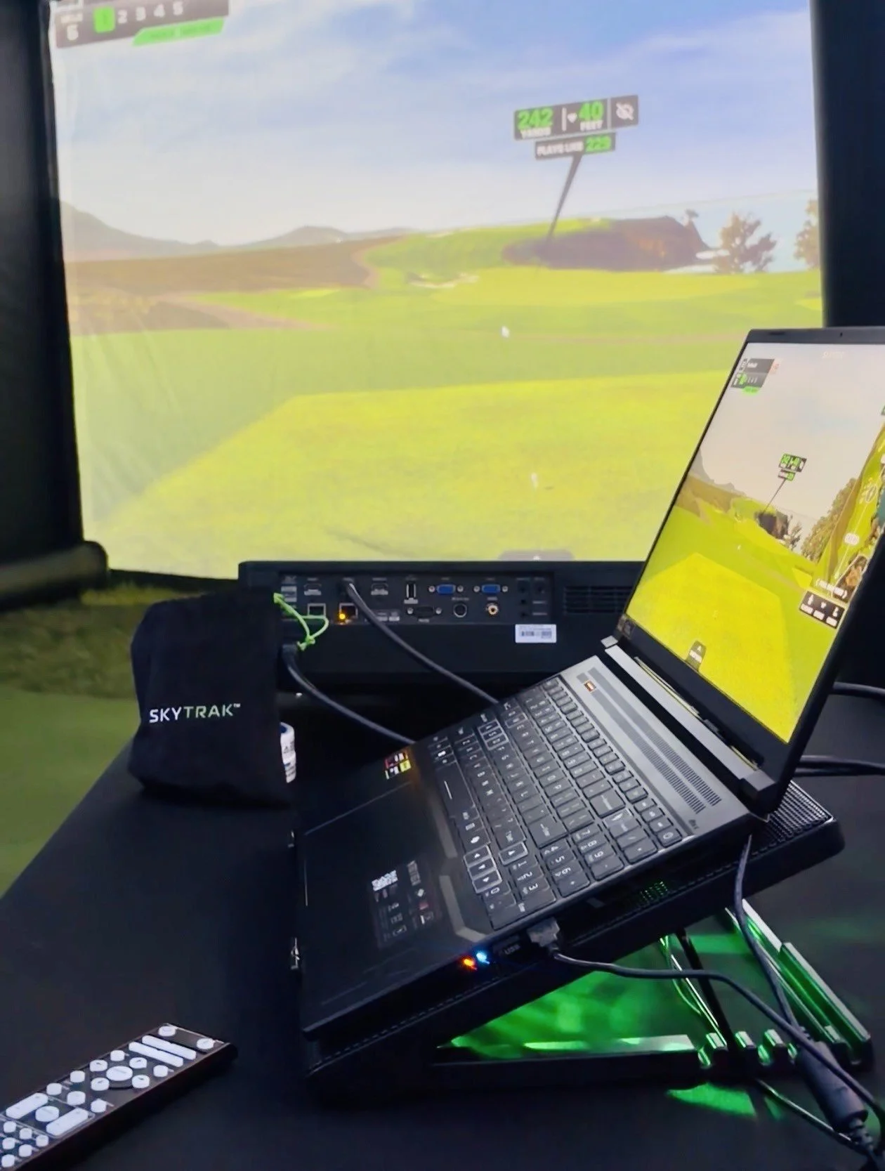 TeeBox2U golf simulator laptop and projector displaying a virtual golf course.
